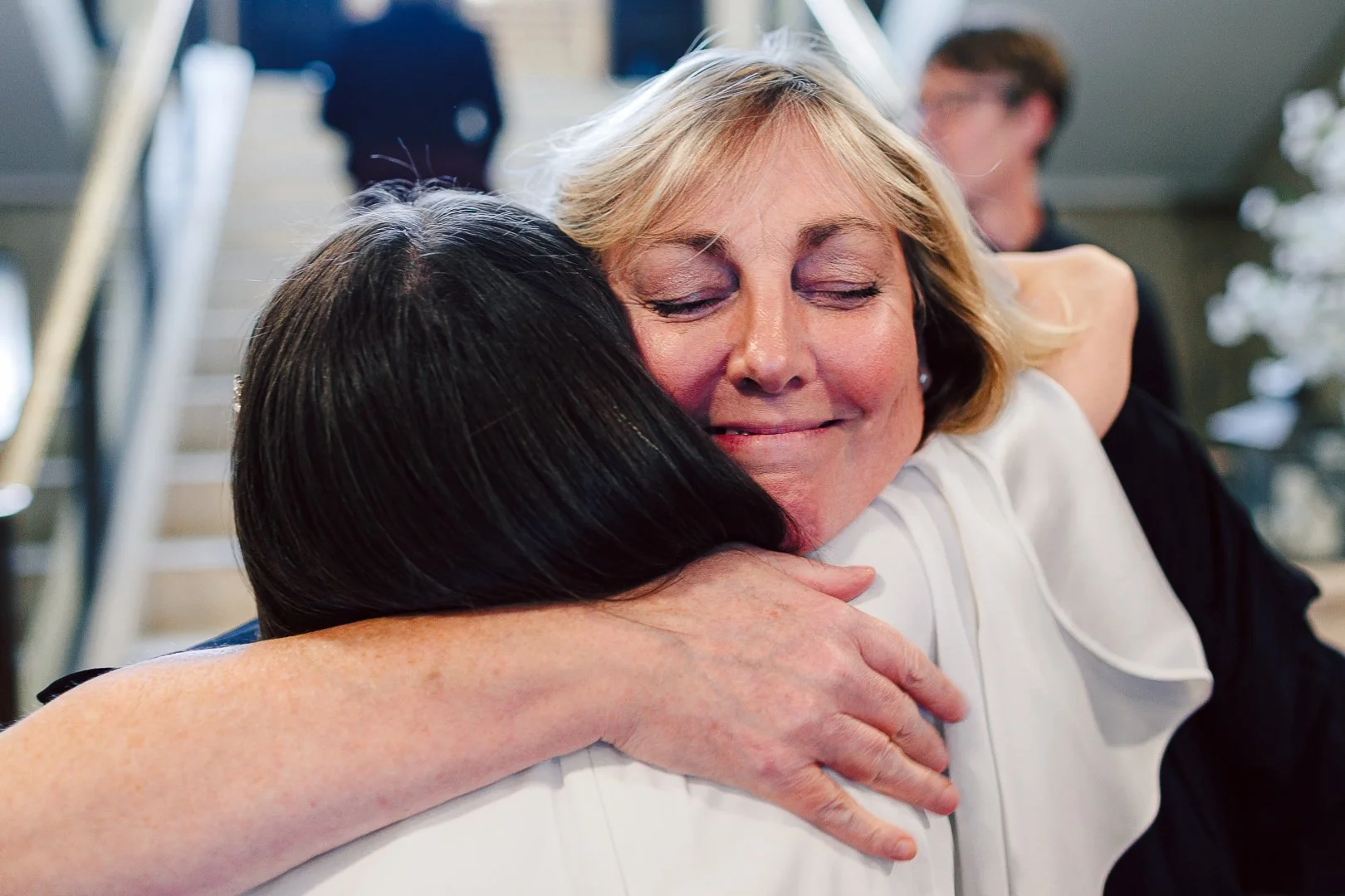 a female guest hugs the bride on her wedding day at Sale Town Hall
