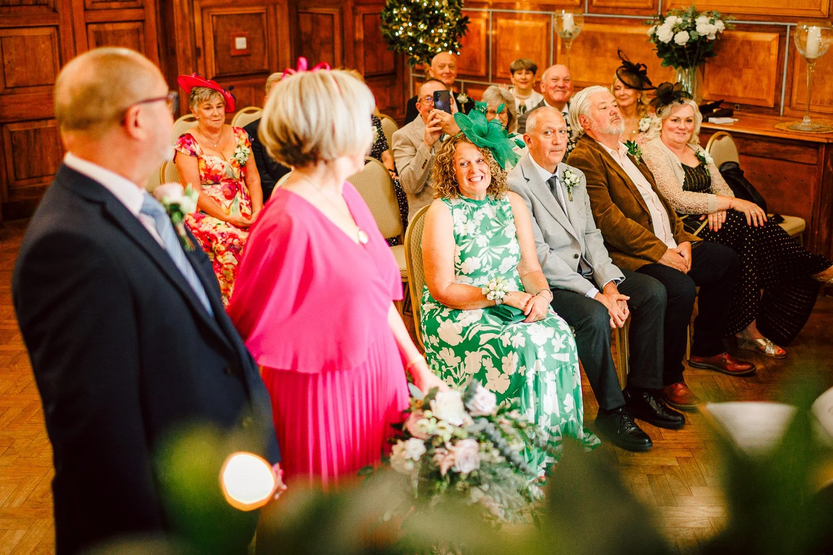 Guests sitting in wooden paneled ceremony room look towards their bride, taken by a Sale Town Hall wedding photographer.