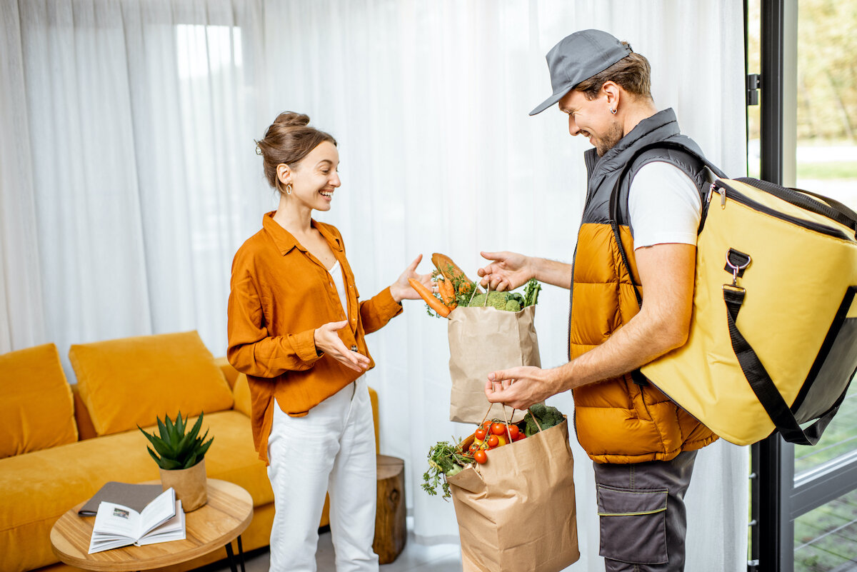 Happy woman receiving order from delivery.jpg