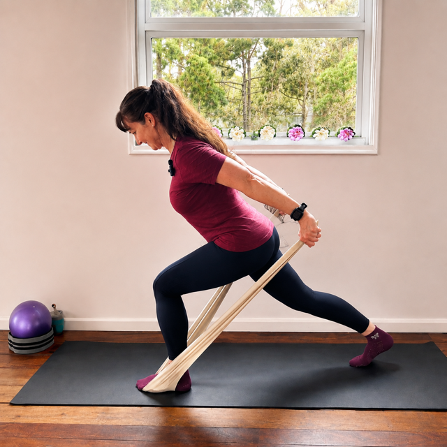 Jodie teaching a lunge with Pilates arms pulls with resistance band