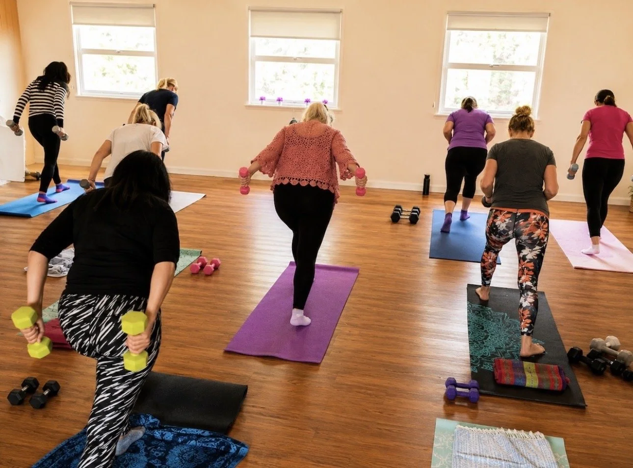 Standing Pilates exercise with hand weights for arm strengthening