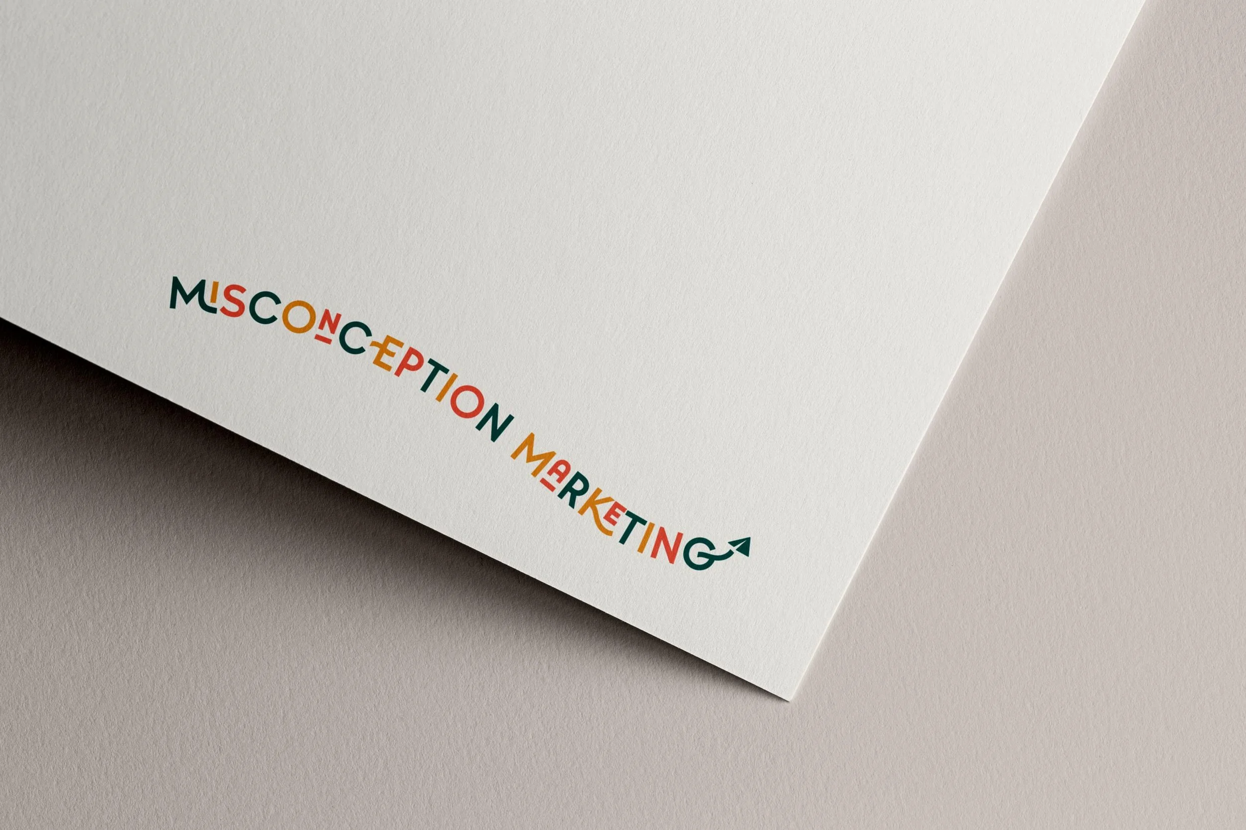 Curved multicoloured logo for Misconception Marketing on the corner of paper sitting on a neutral background