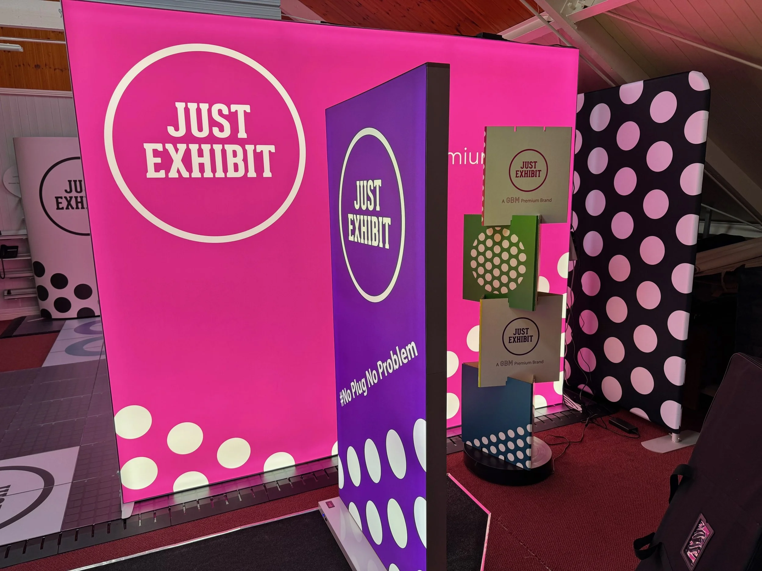 Exhibit display with pink, purple, and polka dot backgrounds featuring