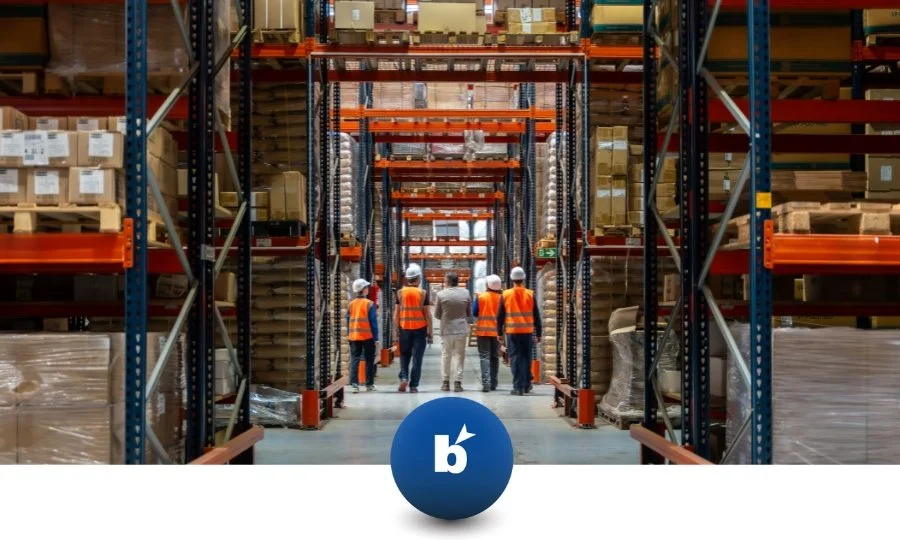 interno di un magazzino pieno di prodotti con 5 operai