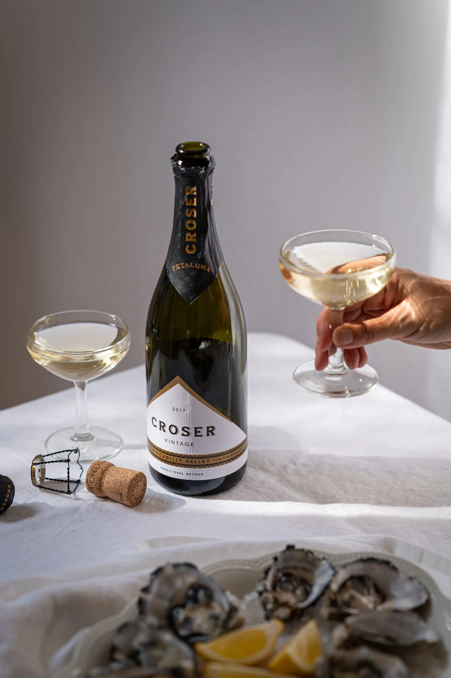 Elegant beverage photography: hand holding glass of sparkling wine by Charlotte Orr, photographer based in Melbourne, Australia