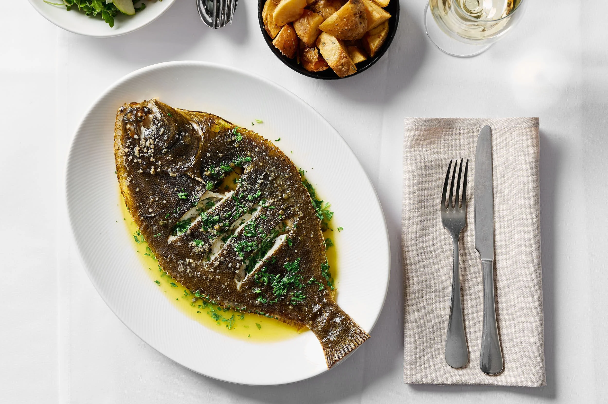 Whole flounder with potatoes photographed for a Melbourne restaurant by Charlotte Orr