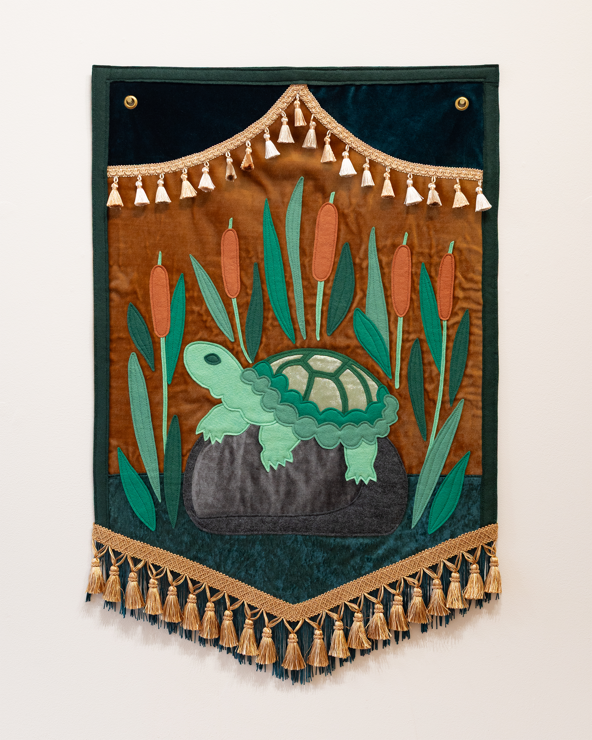 "Turtle in the Cattails" (2025) wool-blend felt, velvet, fringe & tassel trim, thread, brass grommets, 24”x36”
