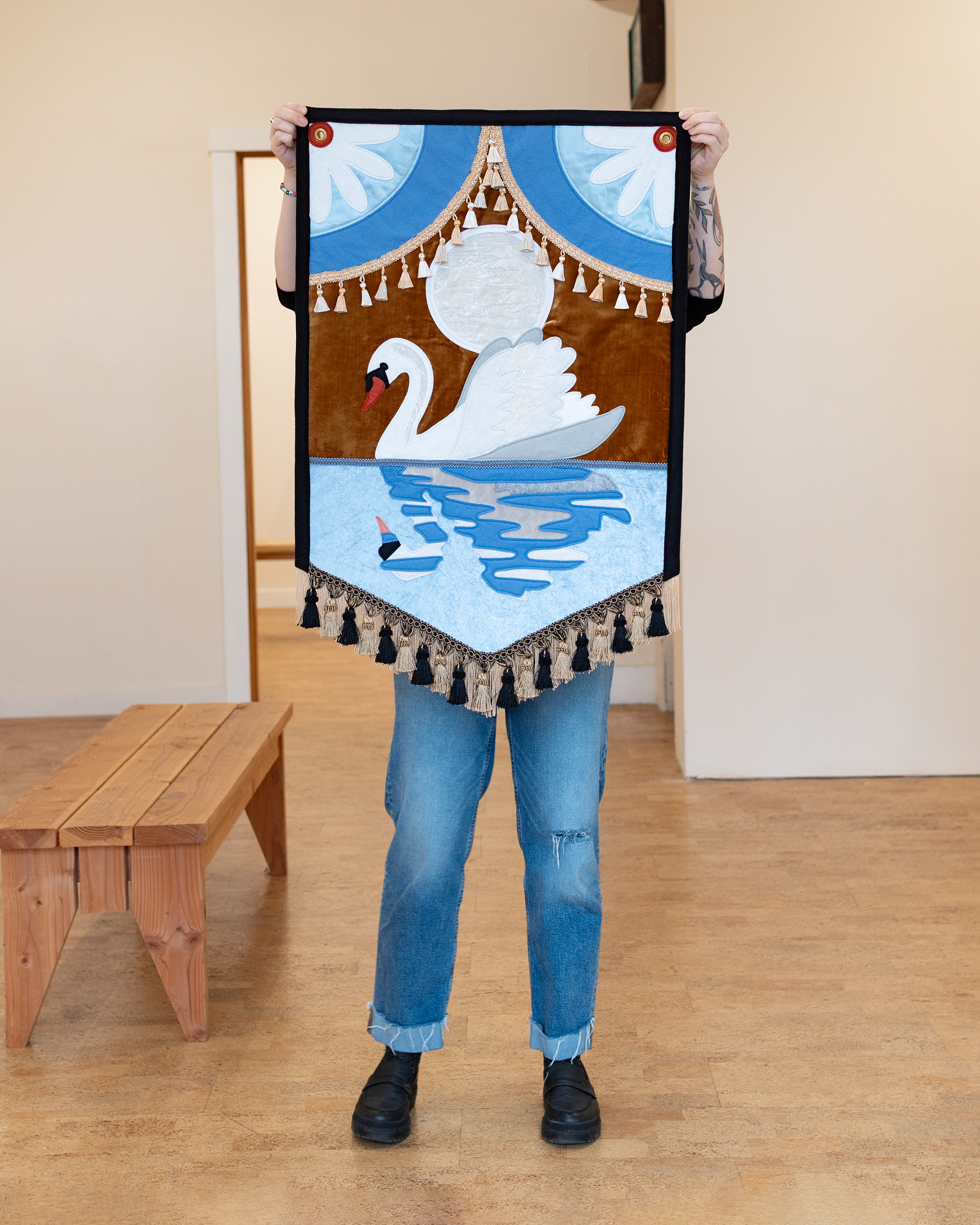 “Swan Song” (2025) wool-blend felt wall banner, velvet, satin, fringe & tassel trim, thread, brass grommets, 24”x37”