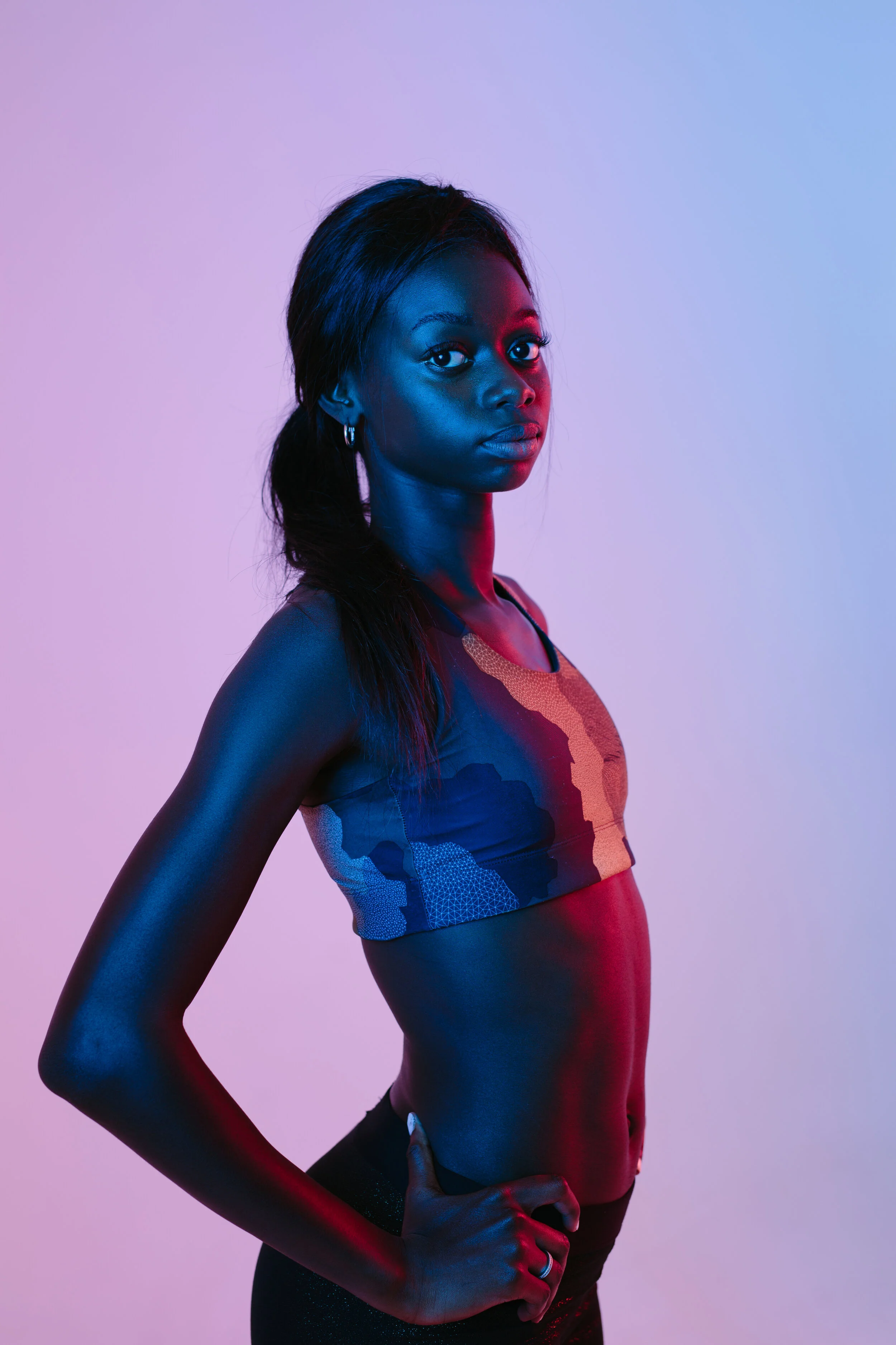 Team Member Aliyah Williams stands with hand on hip against purple background