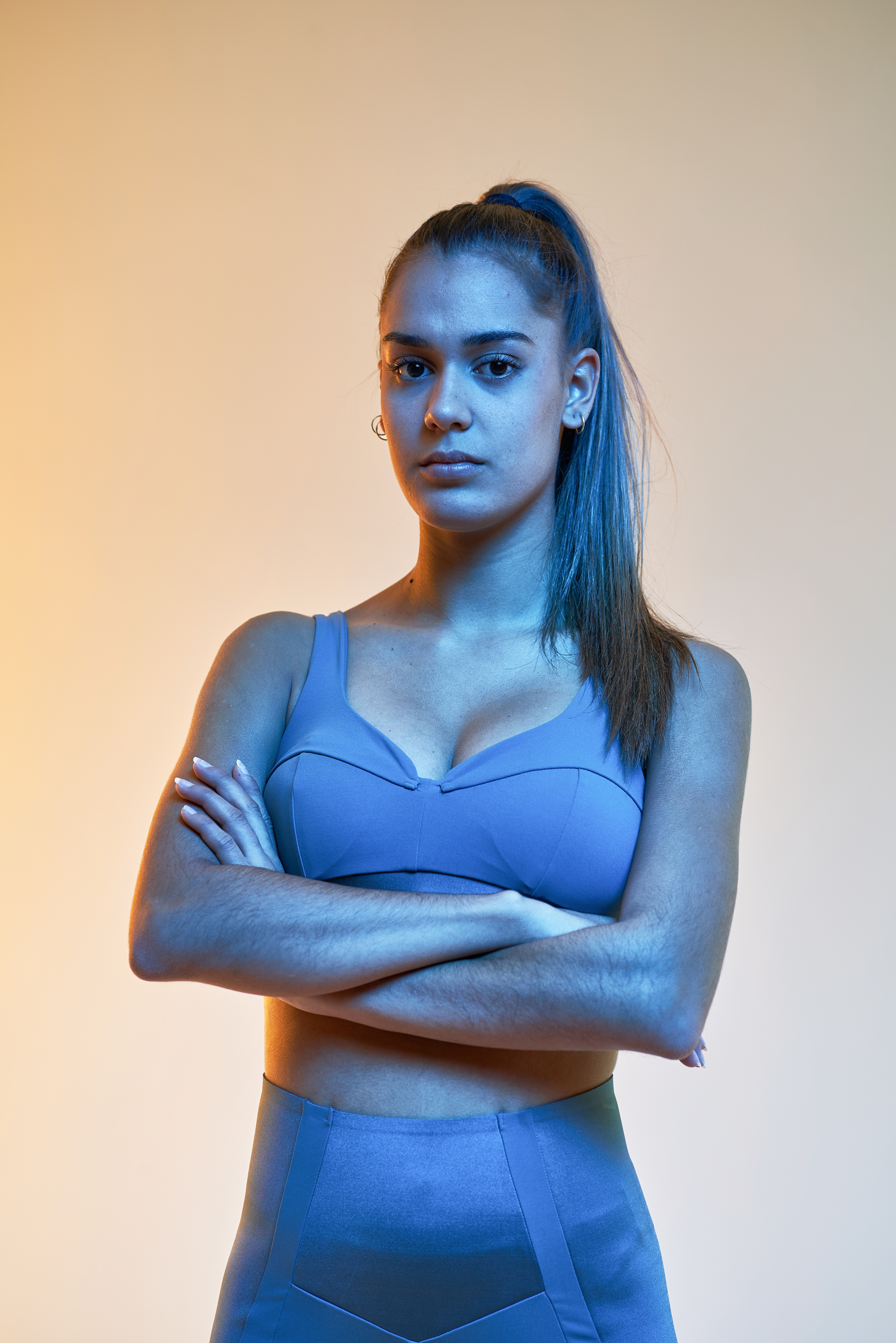 Team Member Nicole Winter stands with arms crossed with gradient background