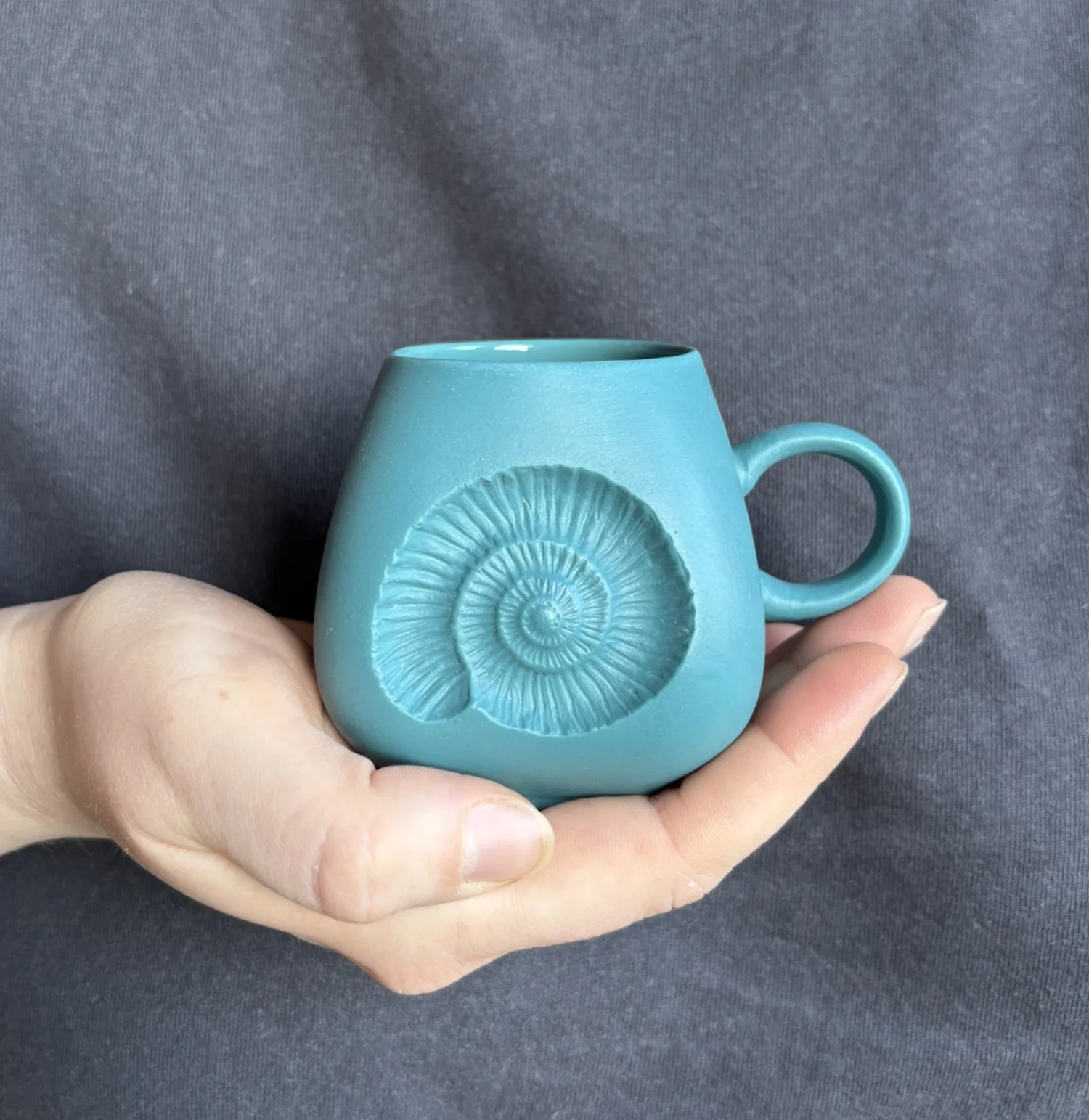 Ammonite espresso mug held teal.jpg