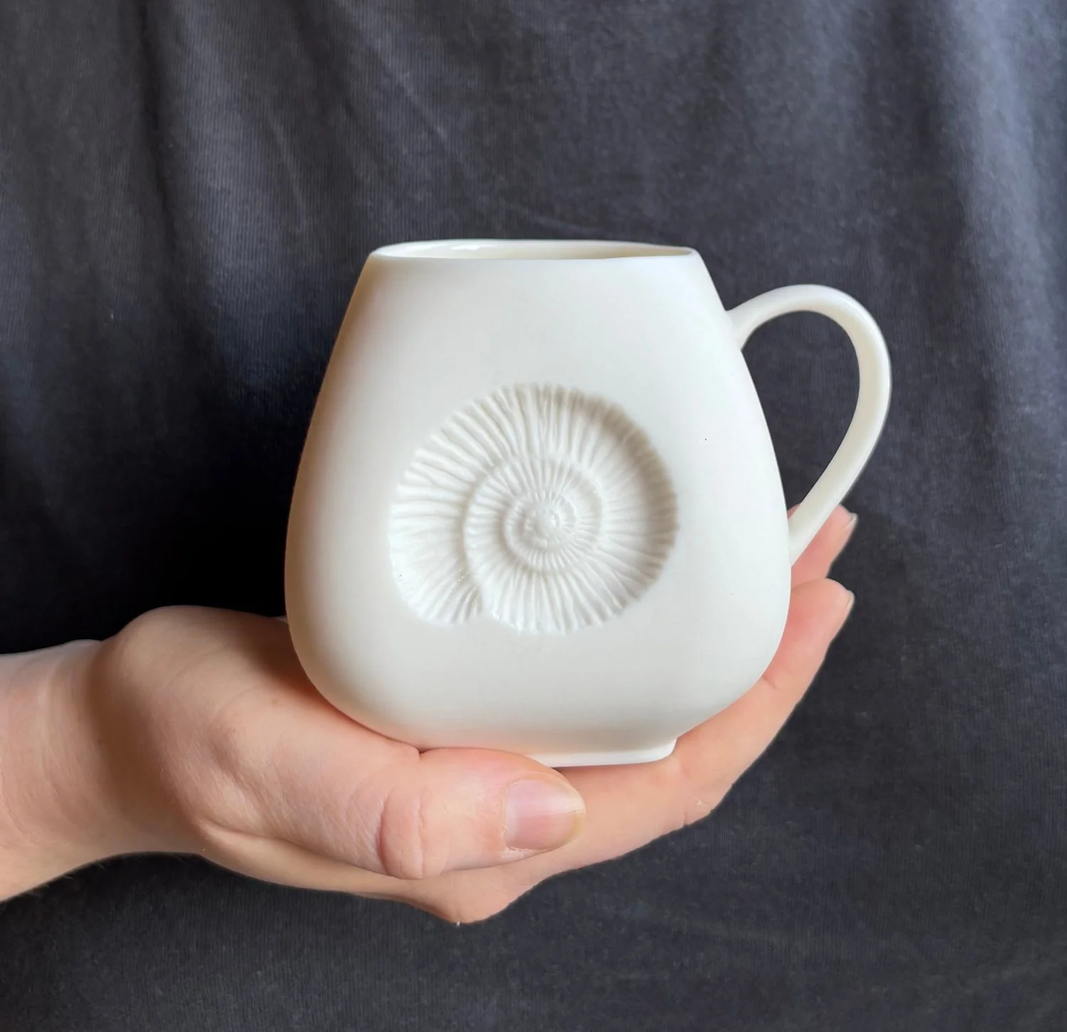 Ammonite Large mug held White.jpg