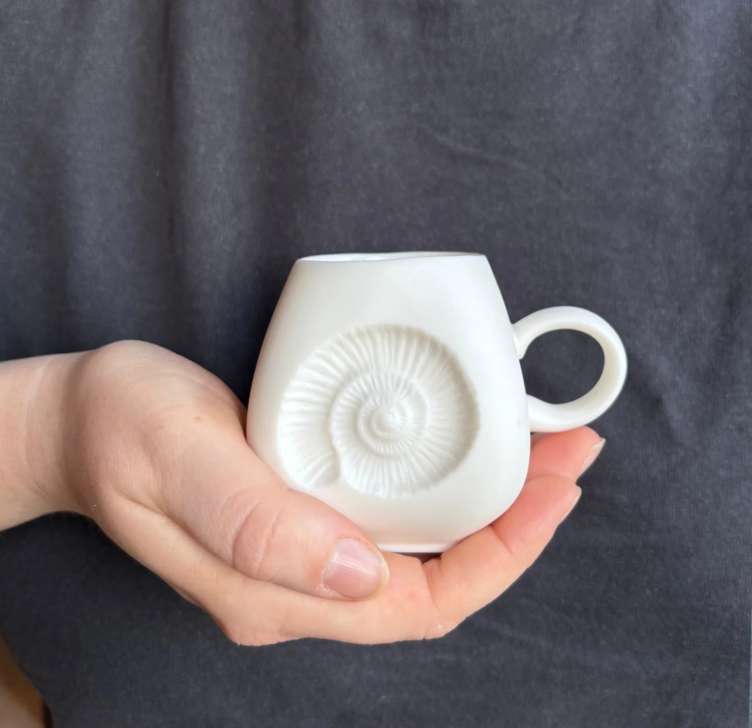 Ammonite espresso mug held white.jpg
