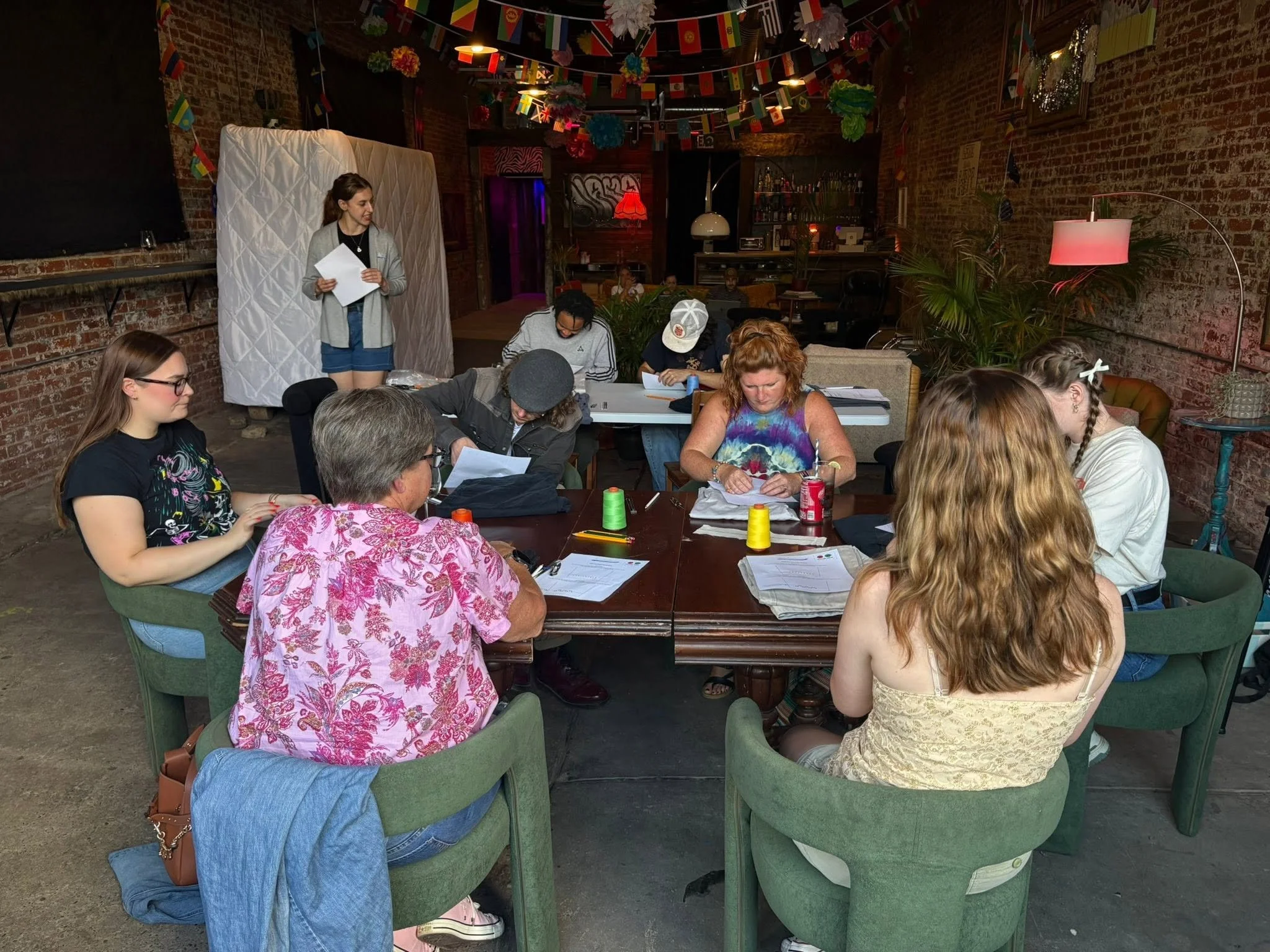 Emily Rouse leads workshop group through hand sewing stitches.