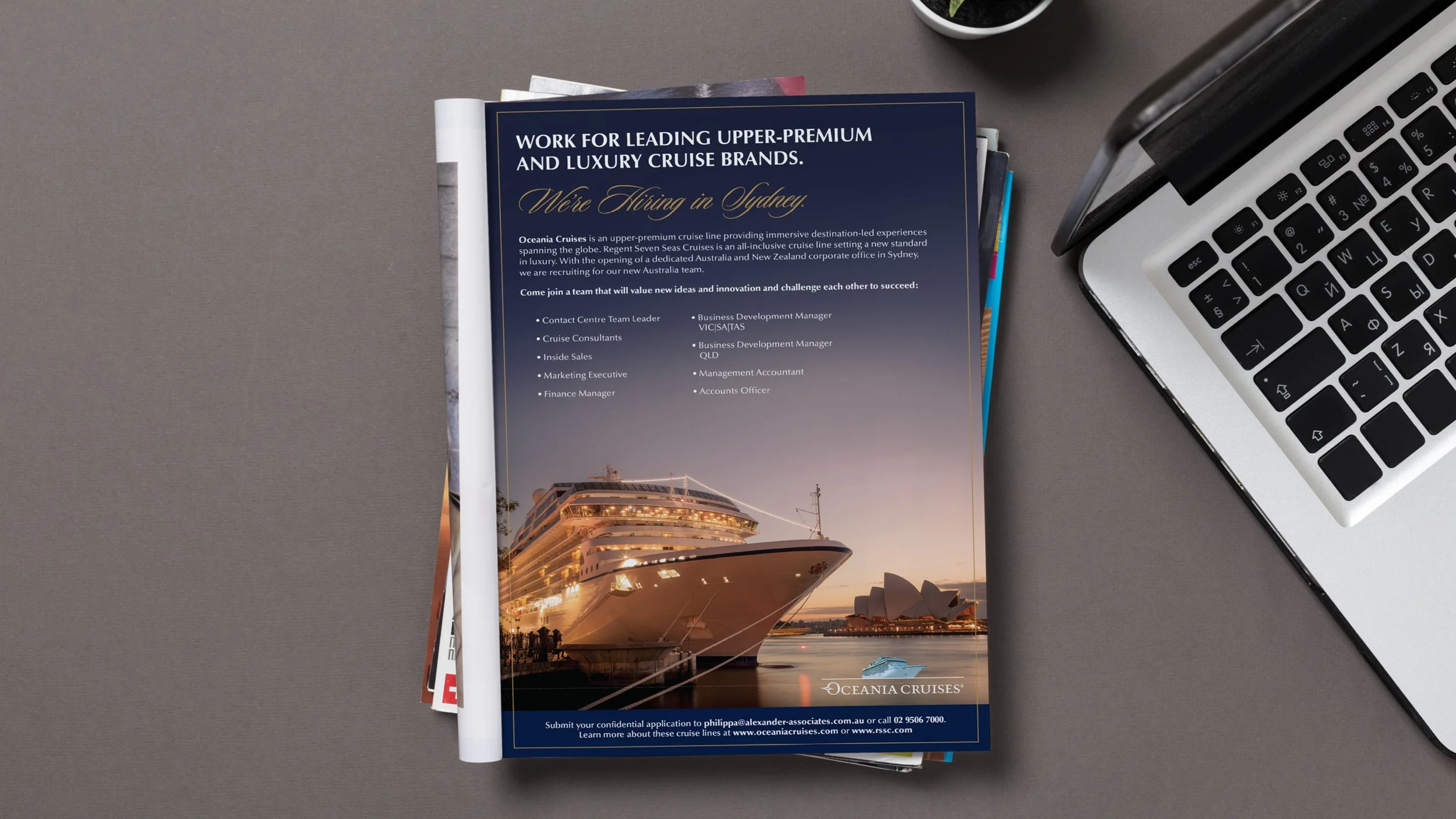 A full page magazine ad for employment at Oceania Cruises displayed in a magazine open on a desk with a laptop nearby.
