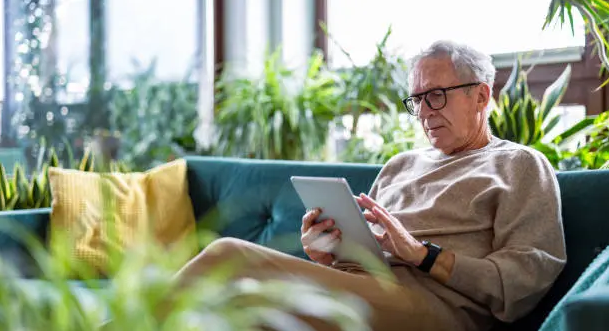 Man relaxing on couch with tablet
