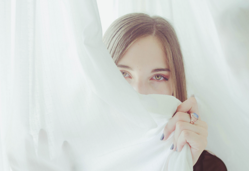 Woman behind curtain