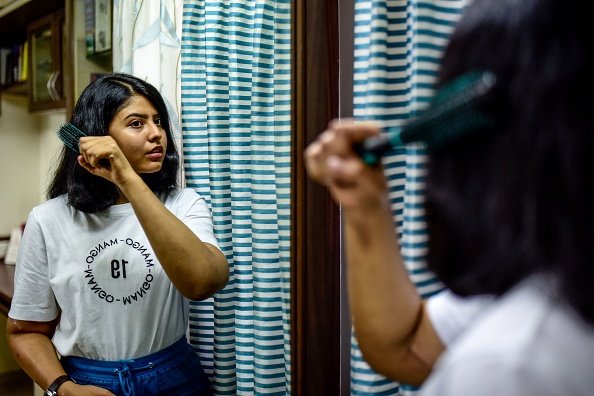   Shreya Siddanagowder, a bilateral hand/arm transplant recipient, brushes her hair more than two years after transplant surgery in India. (Photo by SANKET WANKHADE/AFP via Getty Images)  