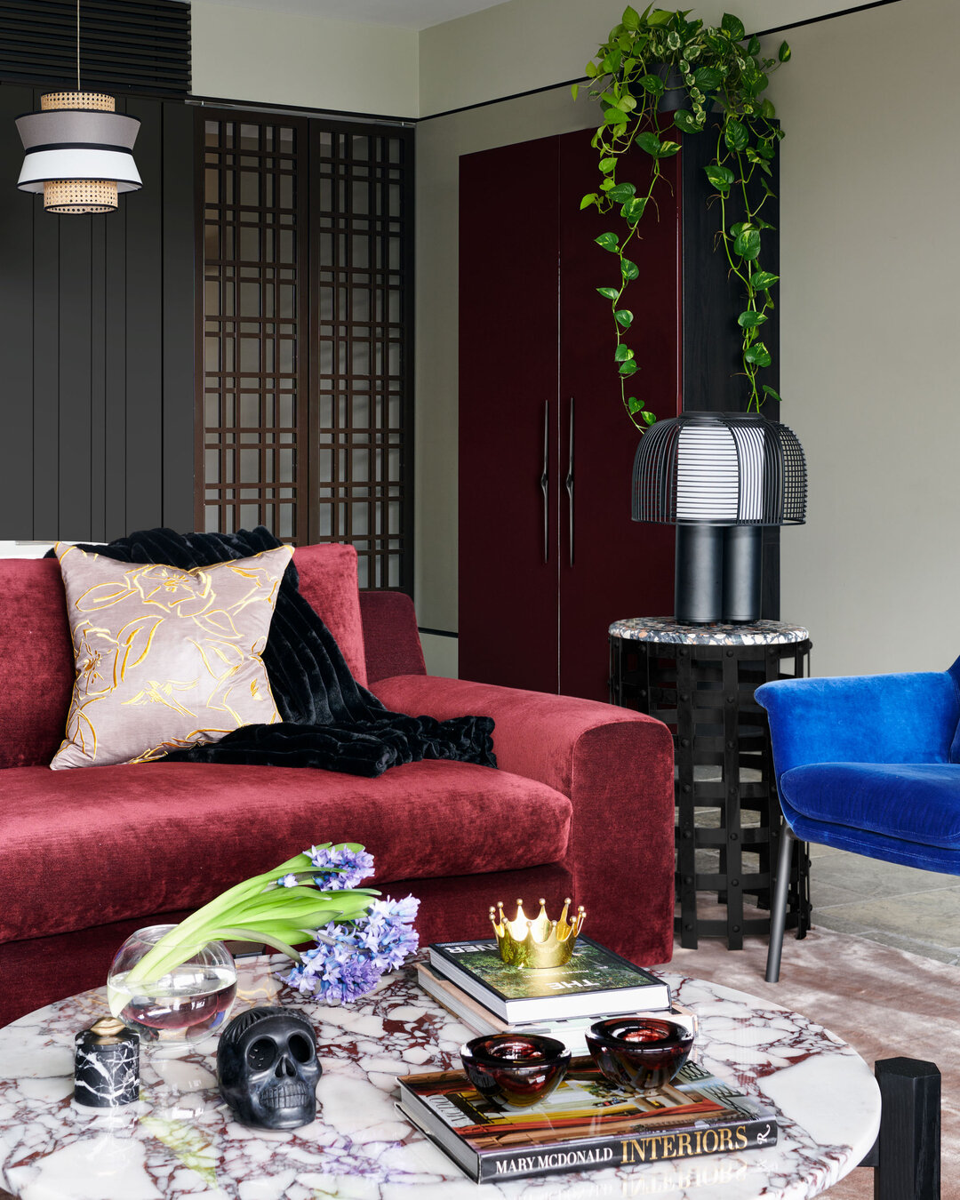 DANKS STREET, HOME &amp; STUDIO - a custom high-gloss burgundy cabinet adds a touch of sleek sophistication, complemented by a luxurious burgundy velvet sofa that beckons relaxation. A burgundy vein marble coffee table becomes the centerpiece, accent