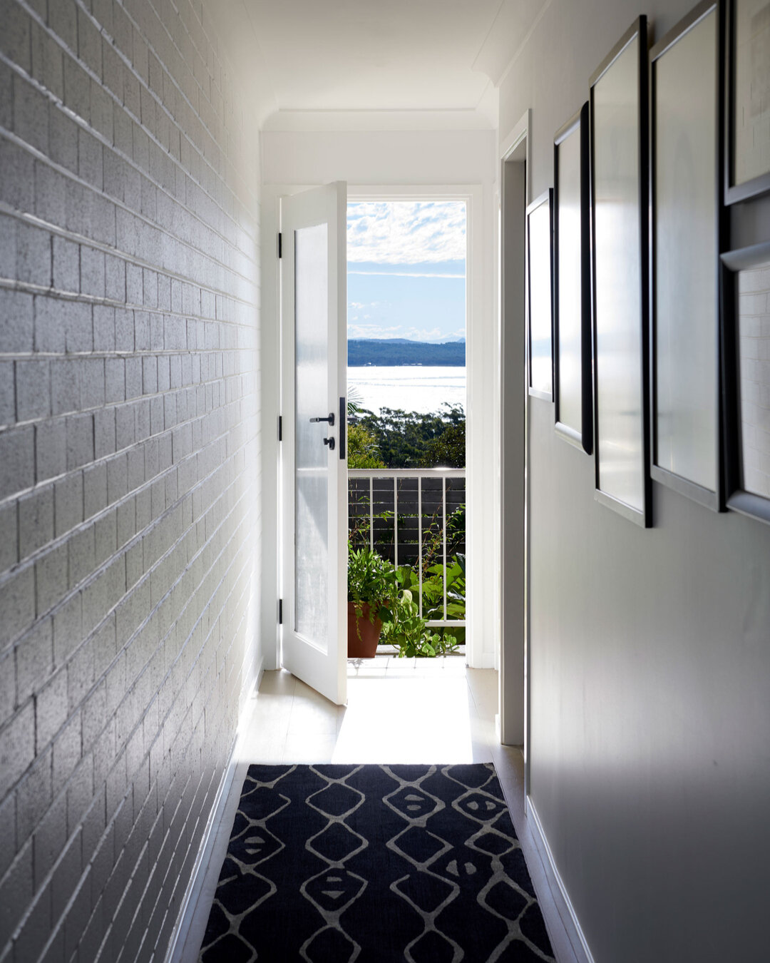 PORT STEPHENS HOUSE I - simplicity and natural beauty converge. The timber floor and white walls create a clean and timeless backdrop. On the left-hand side, painted exposed brick adds a touch of texture and character. On the right-hand side, a galle