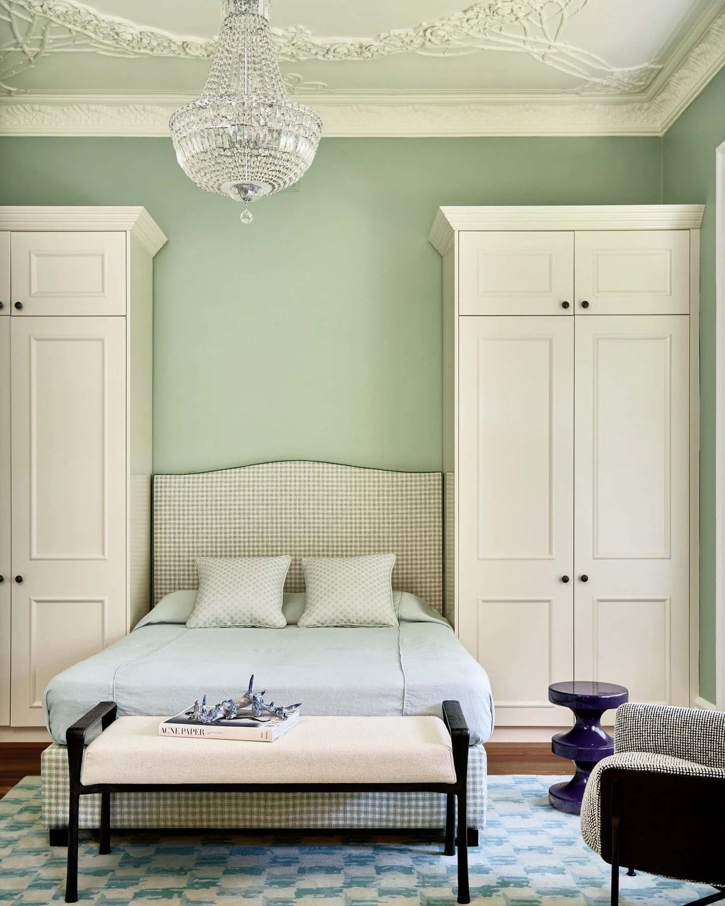 KILLARA HOUSE &ndash; A guest room shaped by softness and proportion.
Pale celadon walls set a calm backdrop for heritage plasterwork and a crystal chandelier, while checks and geometric patterning bring the scheme into the present. A room designed t