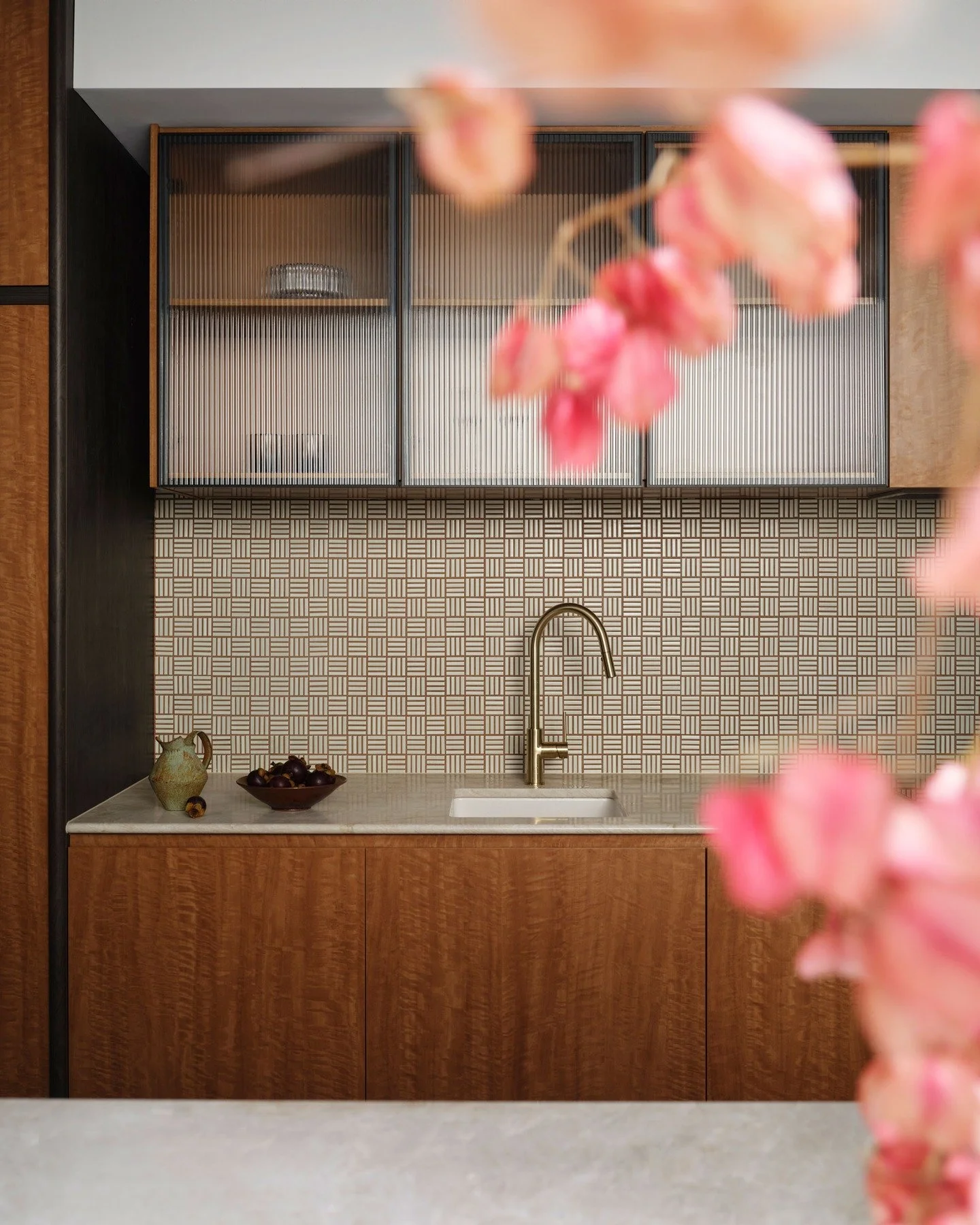 CHIPPENDALE TERRACE HOUSE &mdash; A smart galley kitchen resolved through material and detail. Figured timber joinery, reeded glass cabinetry and a fine basket-weave tiled splashback set the palette. Brass tapware introduces a point of contrast, soft