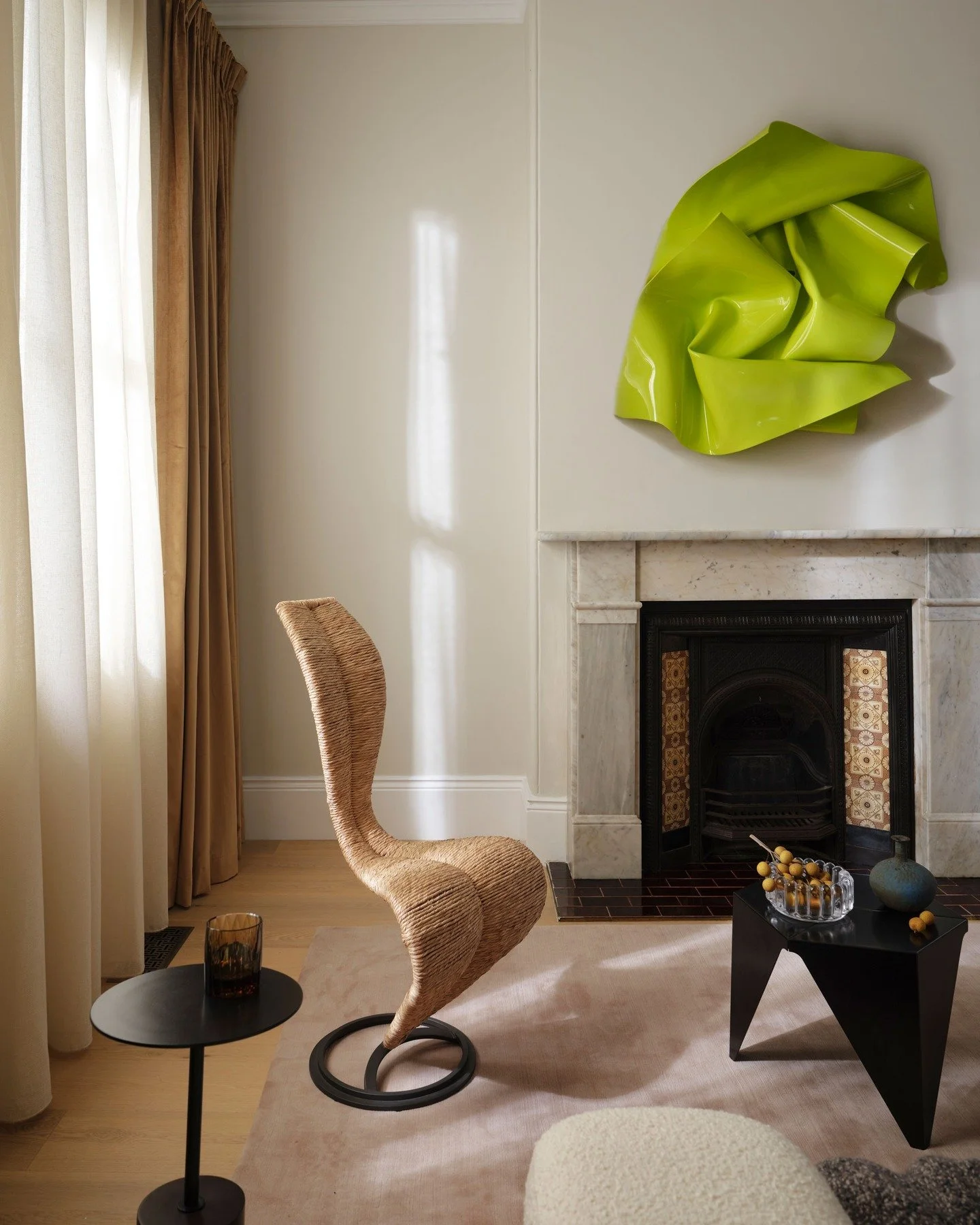 CHIPPENDALE TERRACE HOUSE &mdash; An elegant focal point built on contrast: soft drapery and sculptural S Chair against a crisp marble surround. The chartreuse wall sculpture catches the afternoon light, bringing a cooler edge to an otherwise neutral