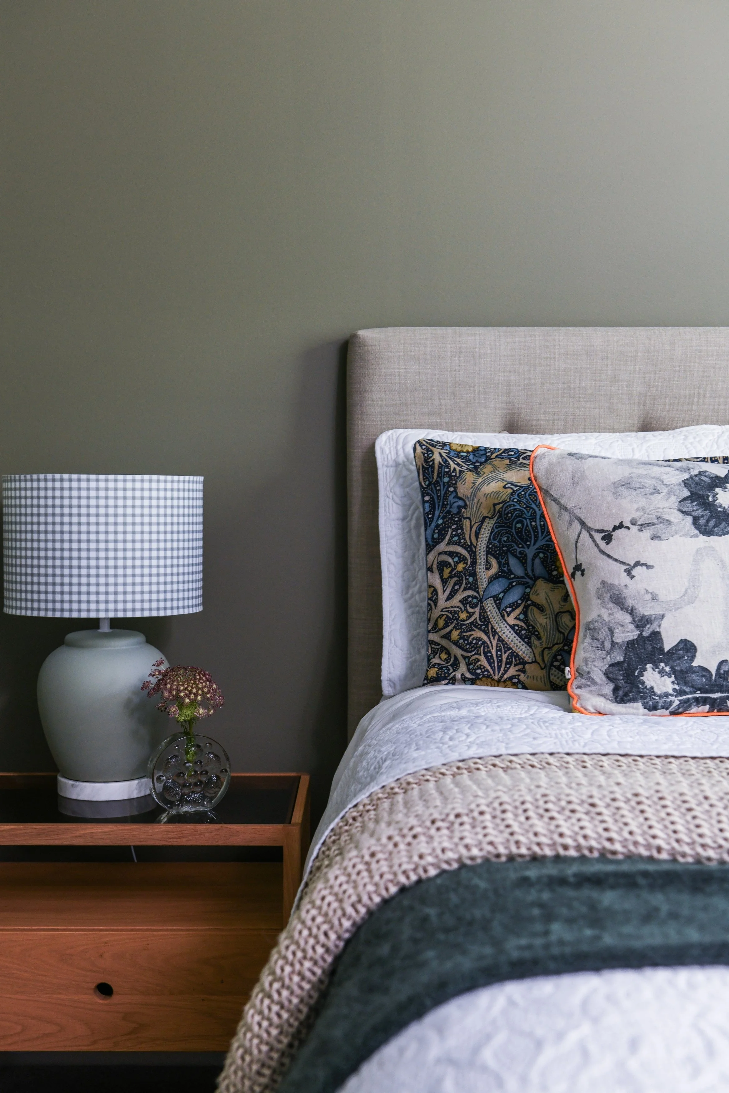 Cosy bedroom, green walls, layered bedding