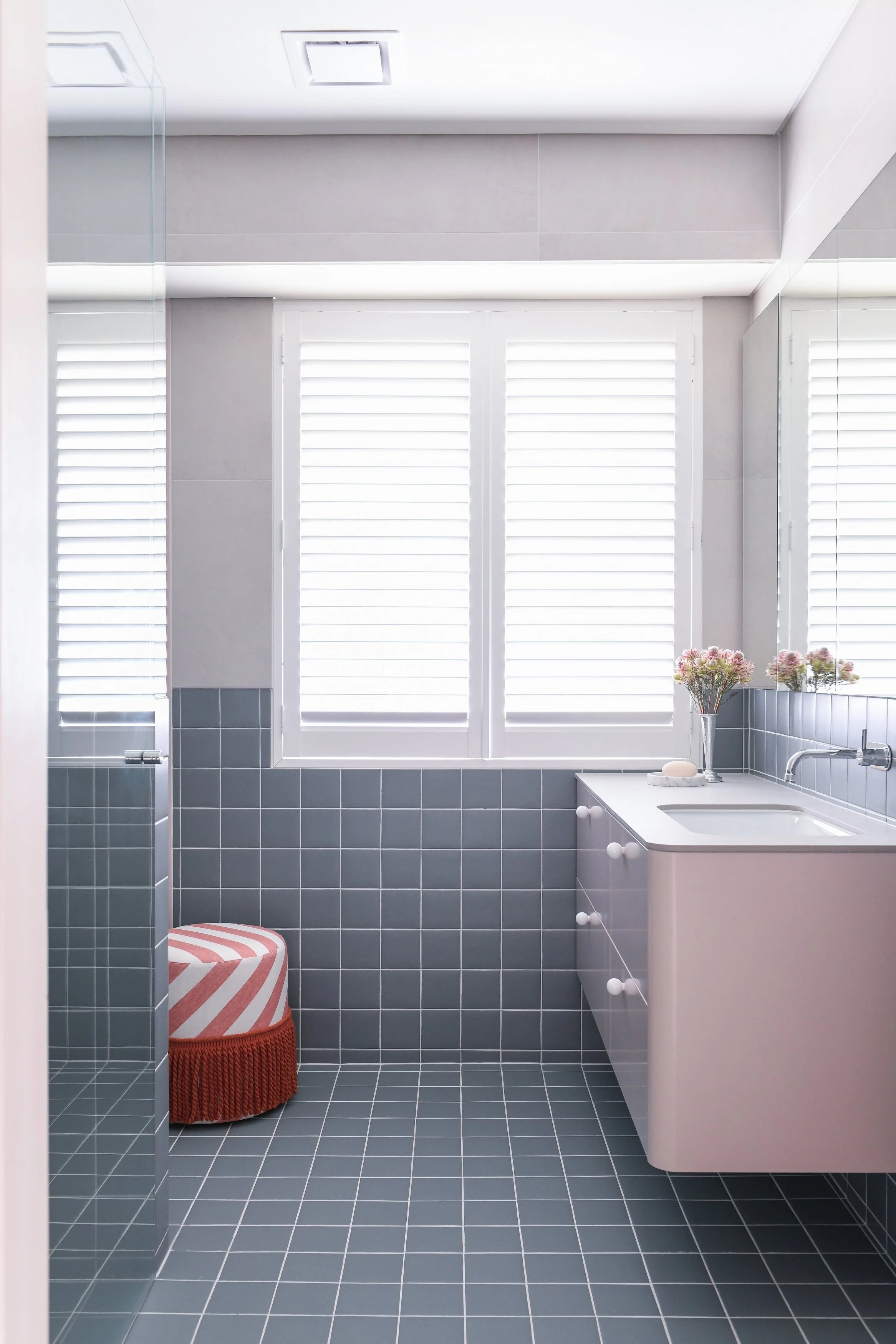 Family bathroom with square blue tile and pink vanity