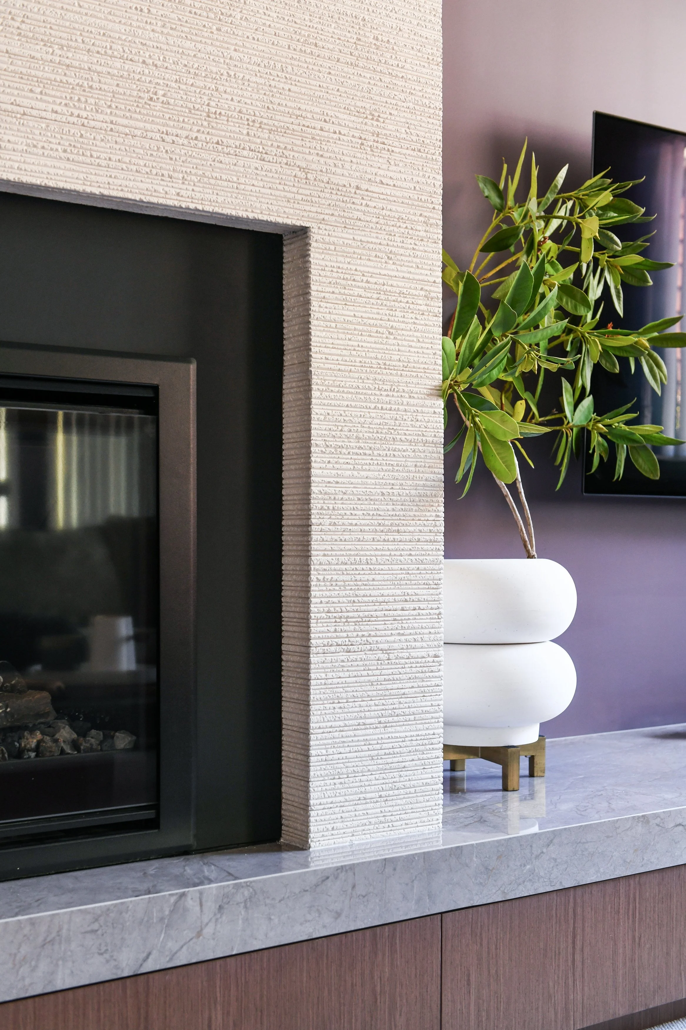 Textural stone fireplace and walnut joinery