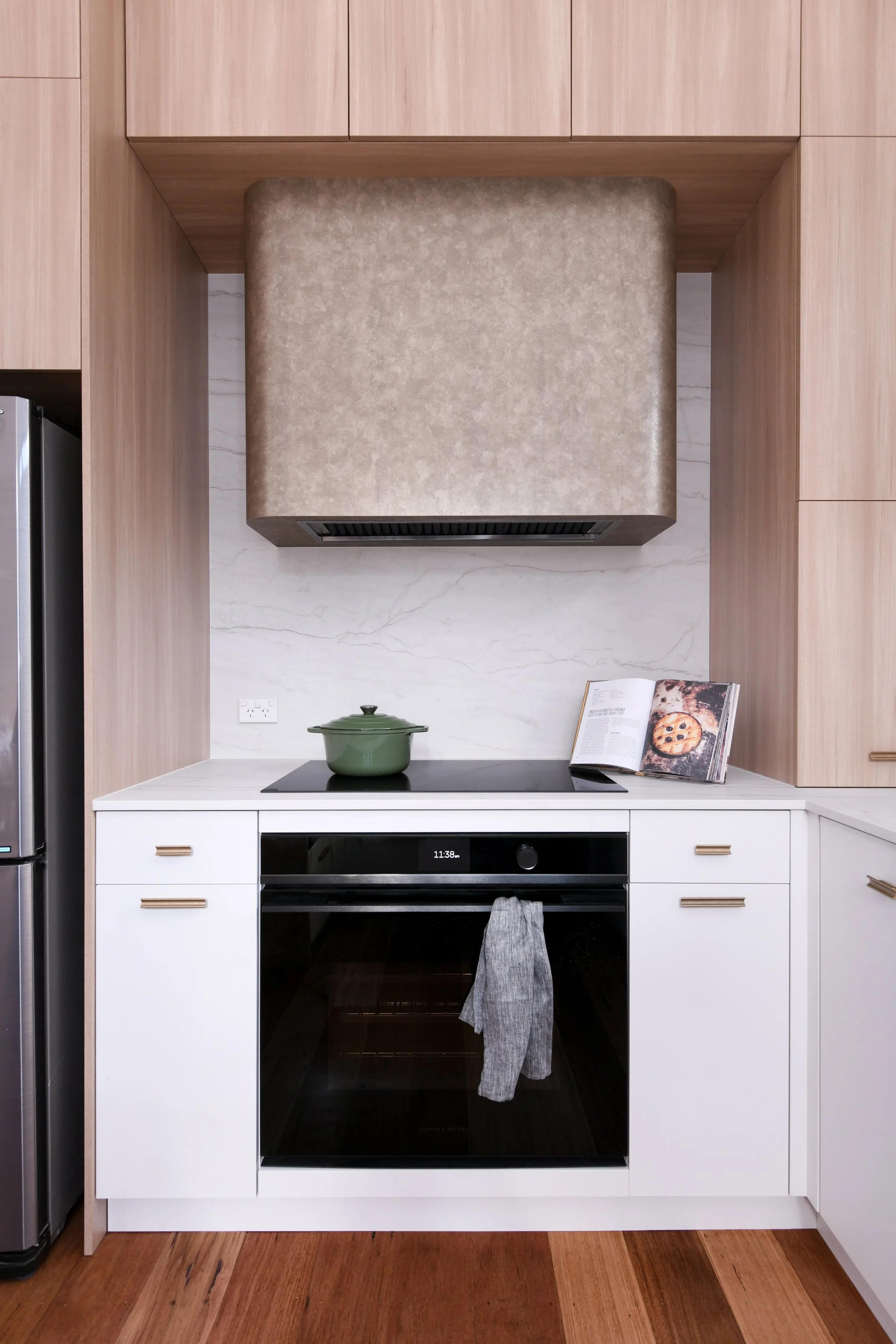Timber and white kitchen with aged metal rangehood