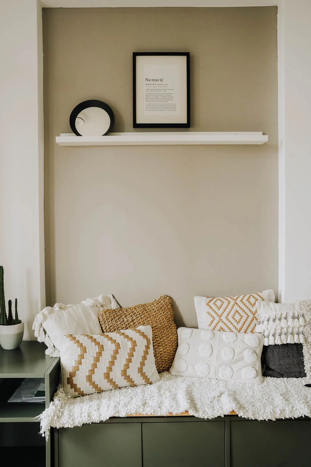 Detailaufnahme einer geschnitzten Holzfigur des hinduistischen Gottes Ganesha, umgeben von Blumen und einer Kerze.