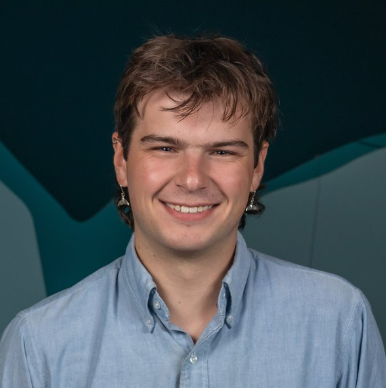 Smiling man with earrings and a blue dress shirt
