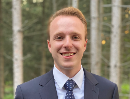 Smiling young man in grey suit with blue tie