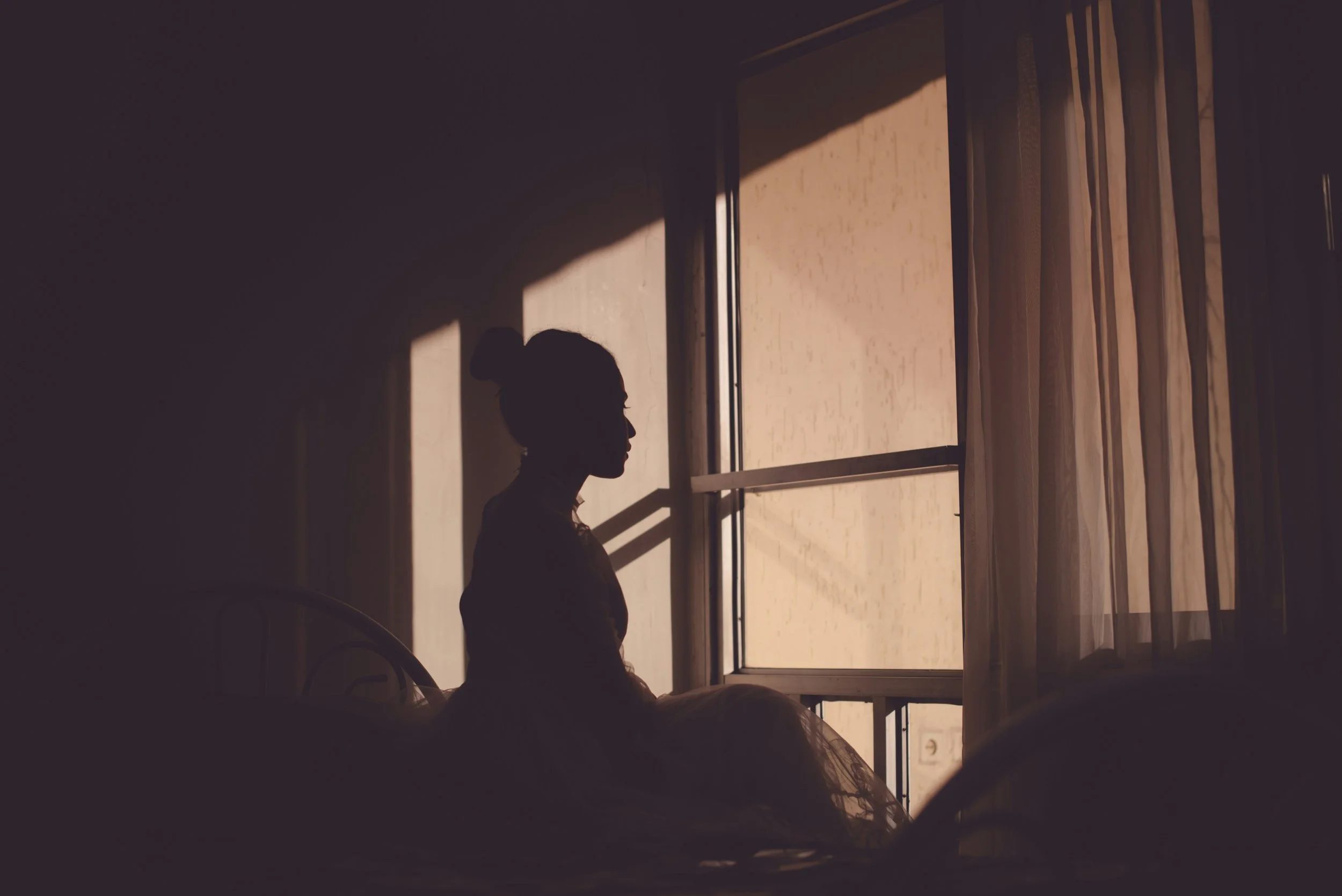 Person alone by window representing emotional isolation and self-abandonment in relationships