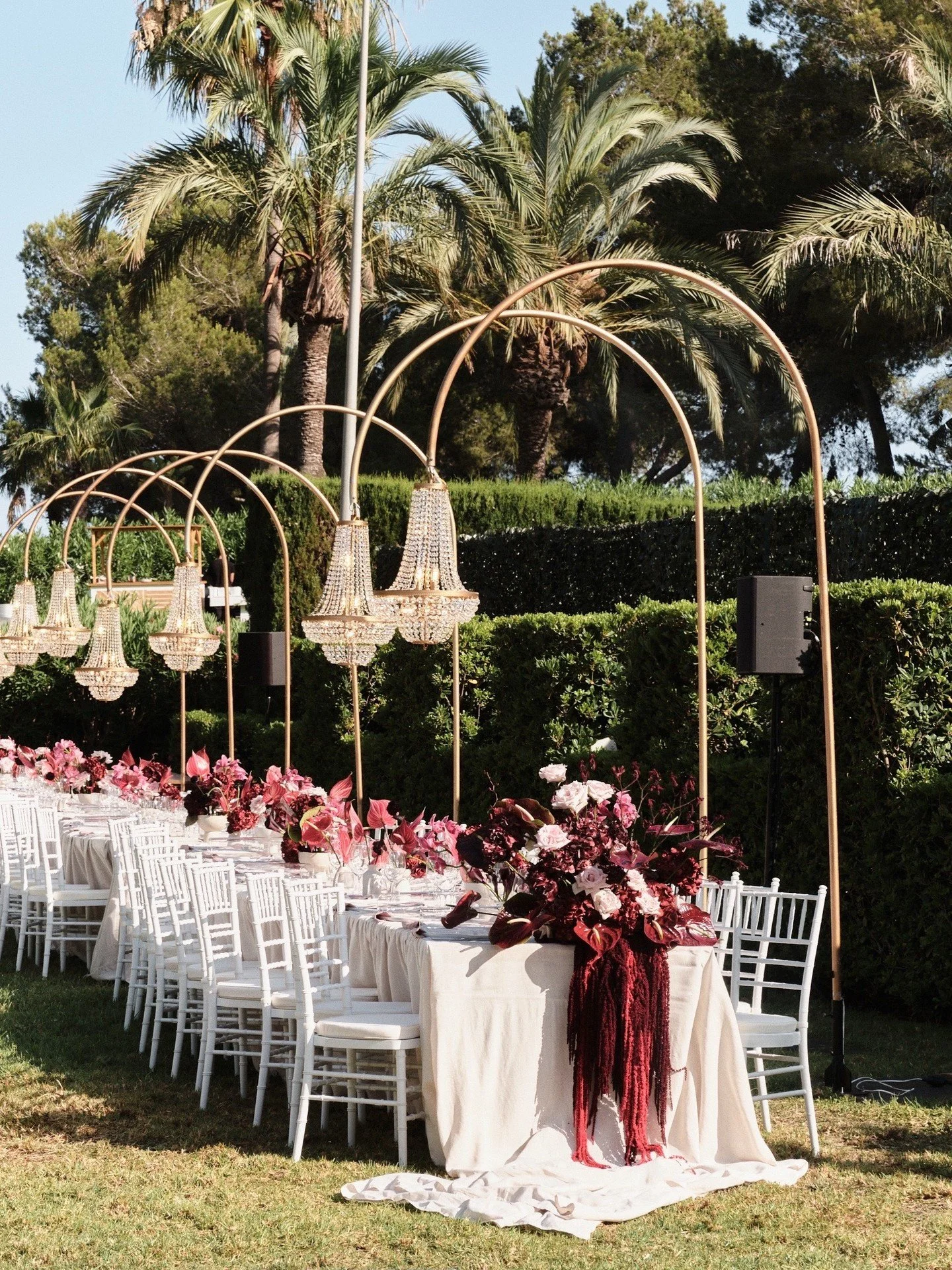 A garden transformed into a dining hall beneath the palms - chandeliers suspended in gold arches, linen falling soft to the ground, florals spilling with a quiet drama.

Wedding Planner &ndash; JC Bespoke Events @jcbespokeevents
Venue - Puig Redo @pu