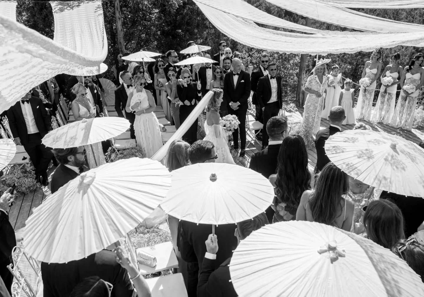 Clouds of gypsophila, gathered in white and the palest pink, lining the aisle as though they had drifted in from the hillside.

Victoria and Charlie married beneath a canopy of lace stretched against the Ibiza sky, the pine forest gathered close arou