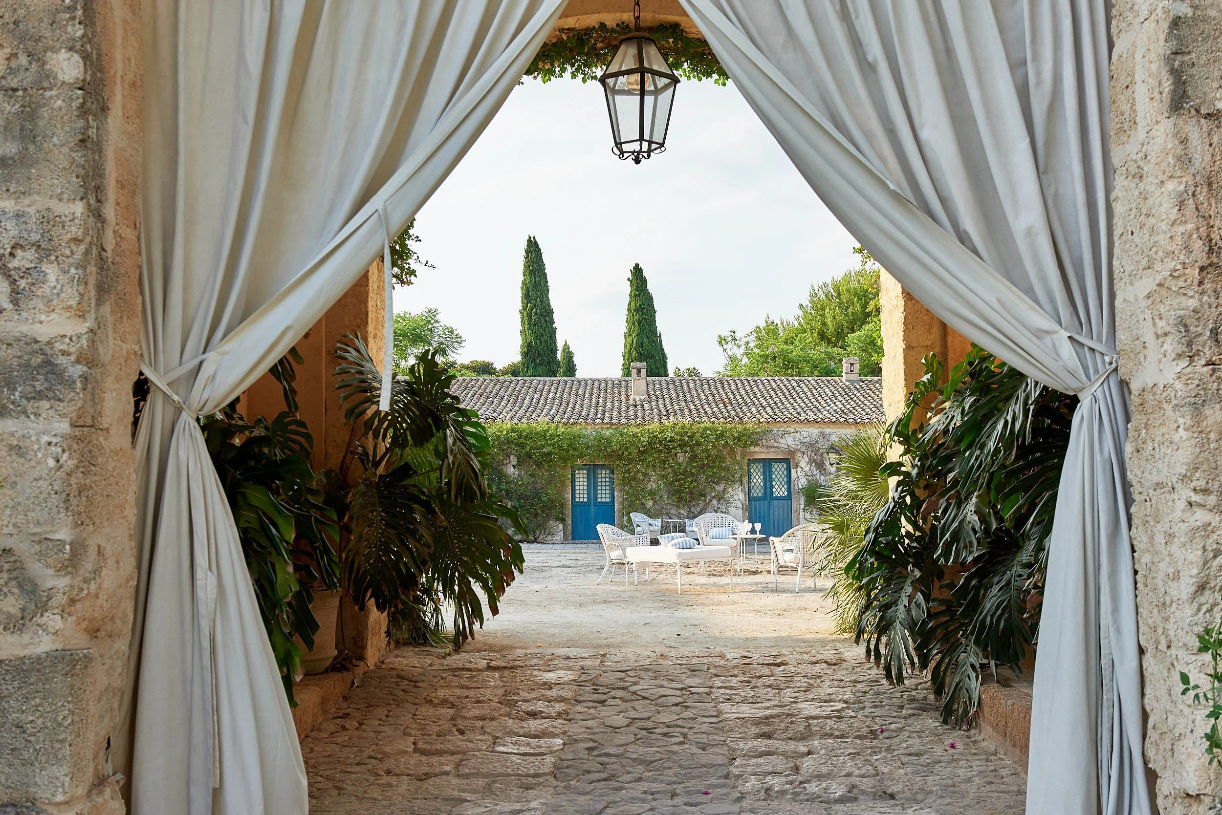 Outdoor doorway with curtains that leads into the outdoor patio of Villa Cornelia