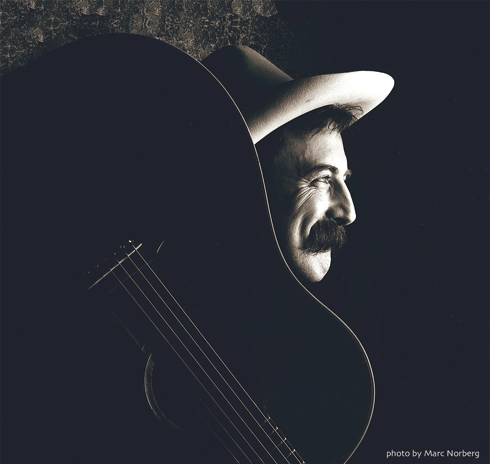 Pop Wagner holds a guitar and wears a cowboy hat