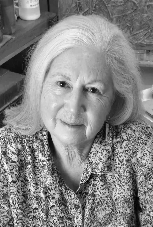 Jackie Henning looks up at the camera wearing a flowered shirt