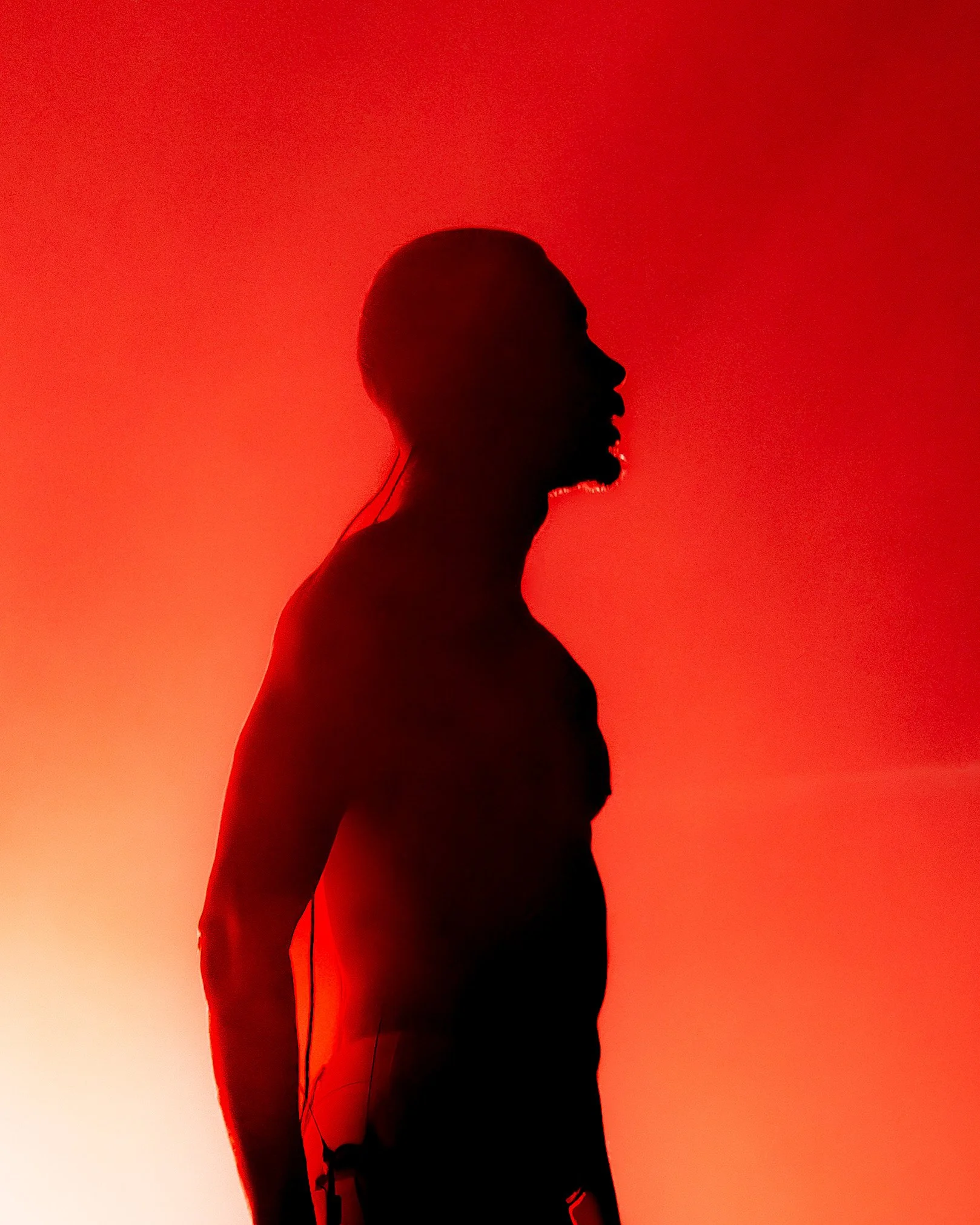 Silhouette of a woman with short hair wearing headphones, standing against a red-orange gradient background.