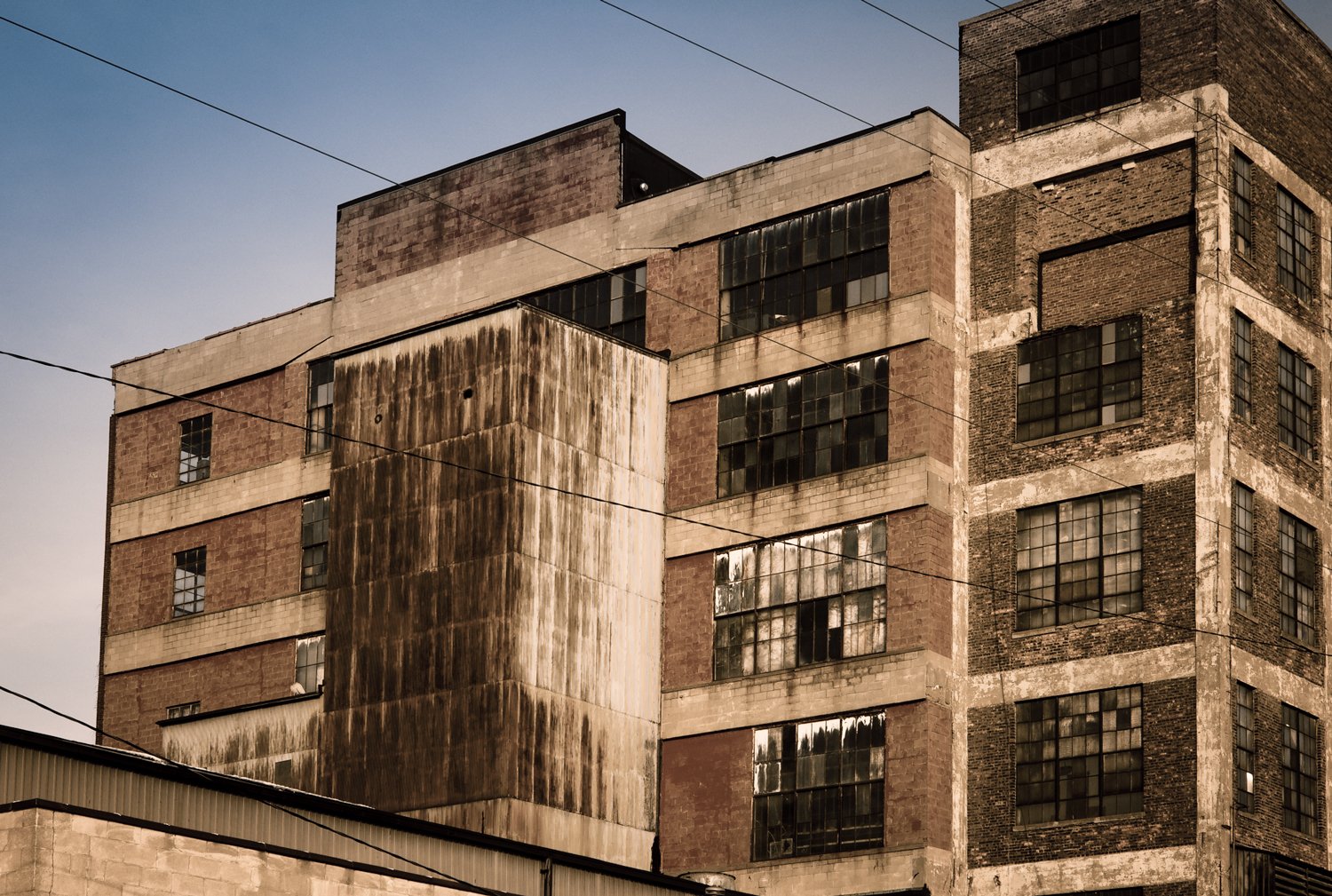 Old industrial building with large windows and weathered exterior