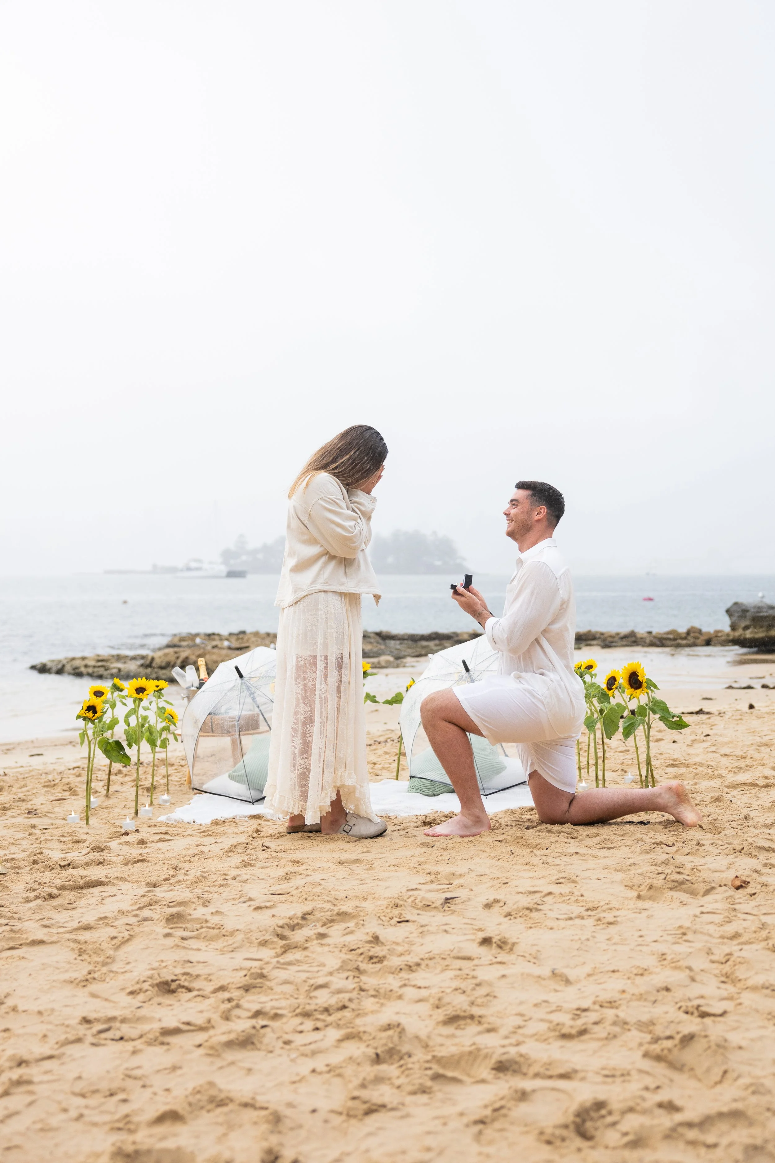 Milk Beach proposal setup Sydney with candles, sunflowers and rose petals at sunset