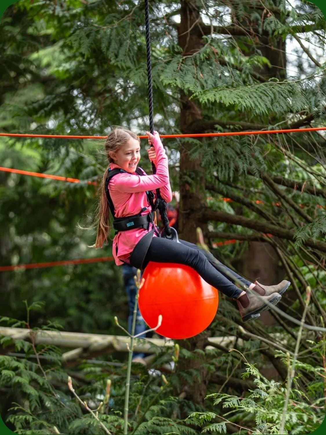 Young girl having fun on adventure at WildPlay outdoor obstacle kids course.