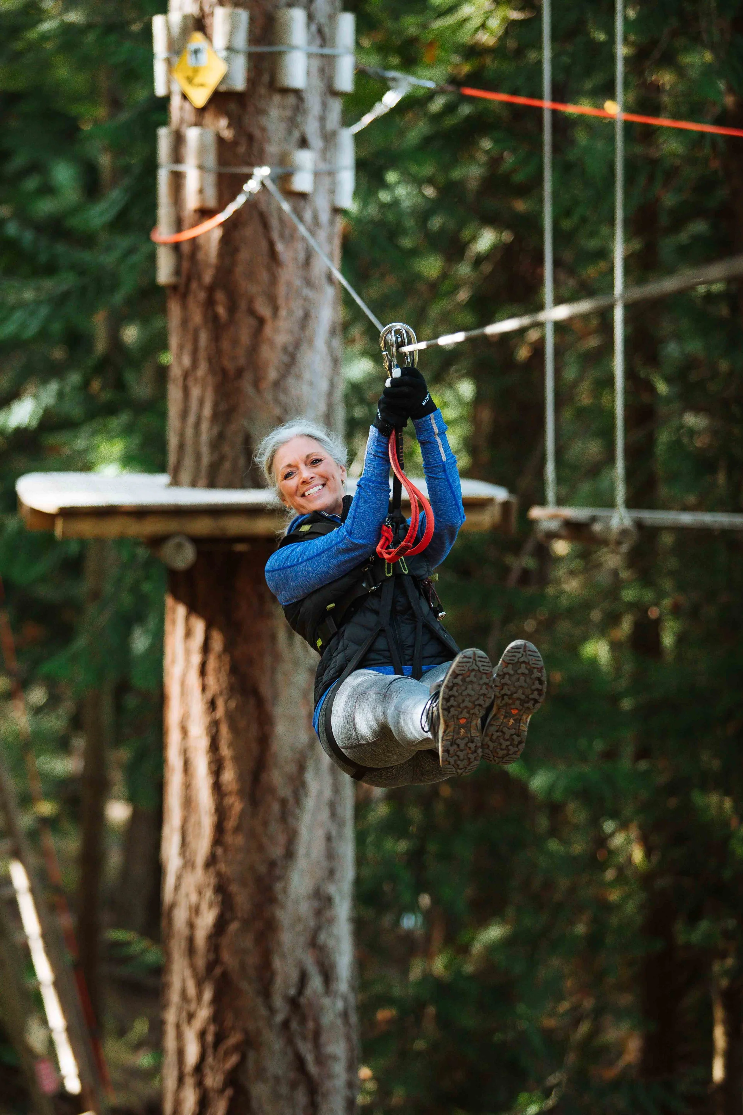 Woman ziplining through the forest at WildPlay Nanaimo in British Columbia.