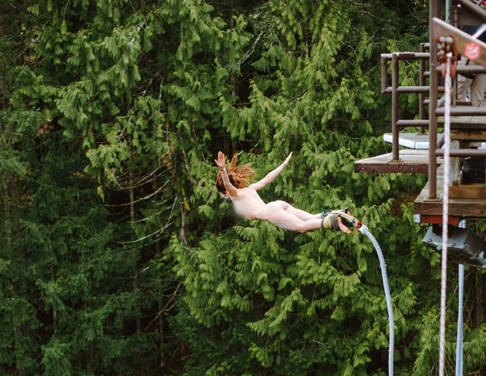 Person in mid-air after jumping off a platform into a body of water.