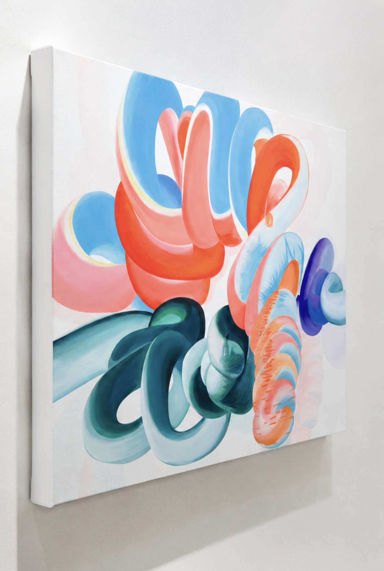 Close-up of a colorful abstract painting with swirling shapes in blue, orange, green, and pink on a white canvas.