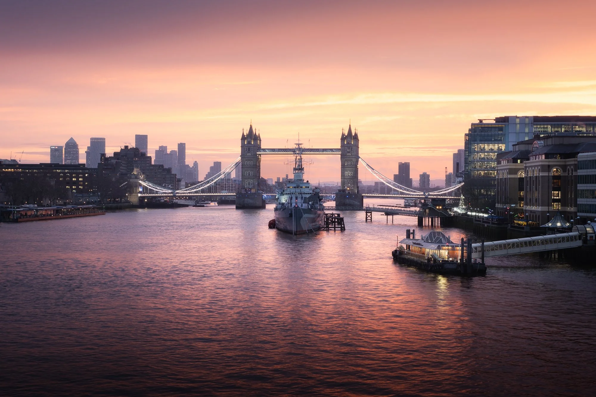 London cityscape at sunrise from London Bridge, featuring HMS Belfast and Tower Bridge