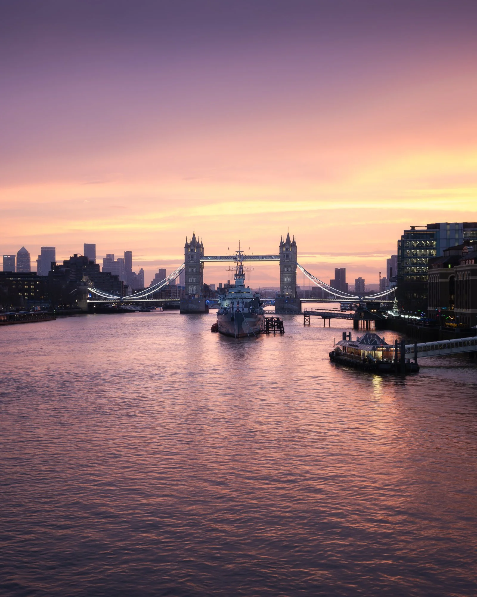 London cityscape at sunrise from London Bridge, featuring HMS Belfast and Tower Bridge