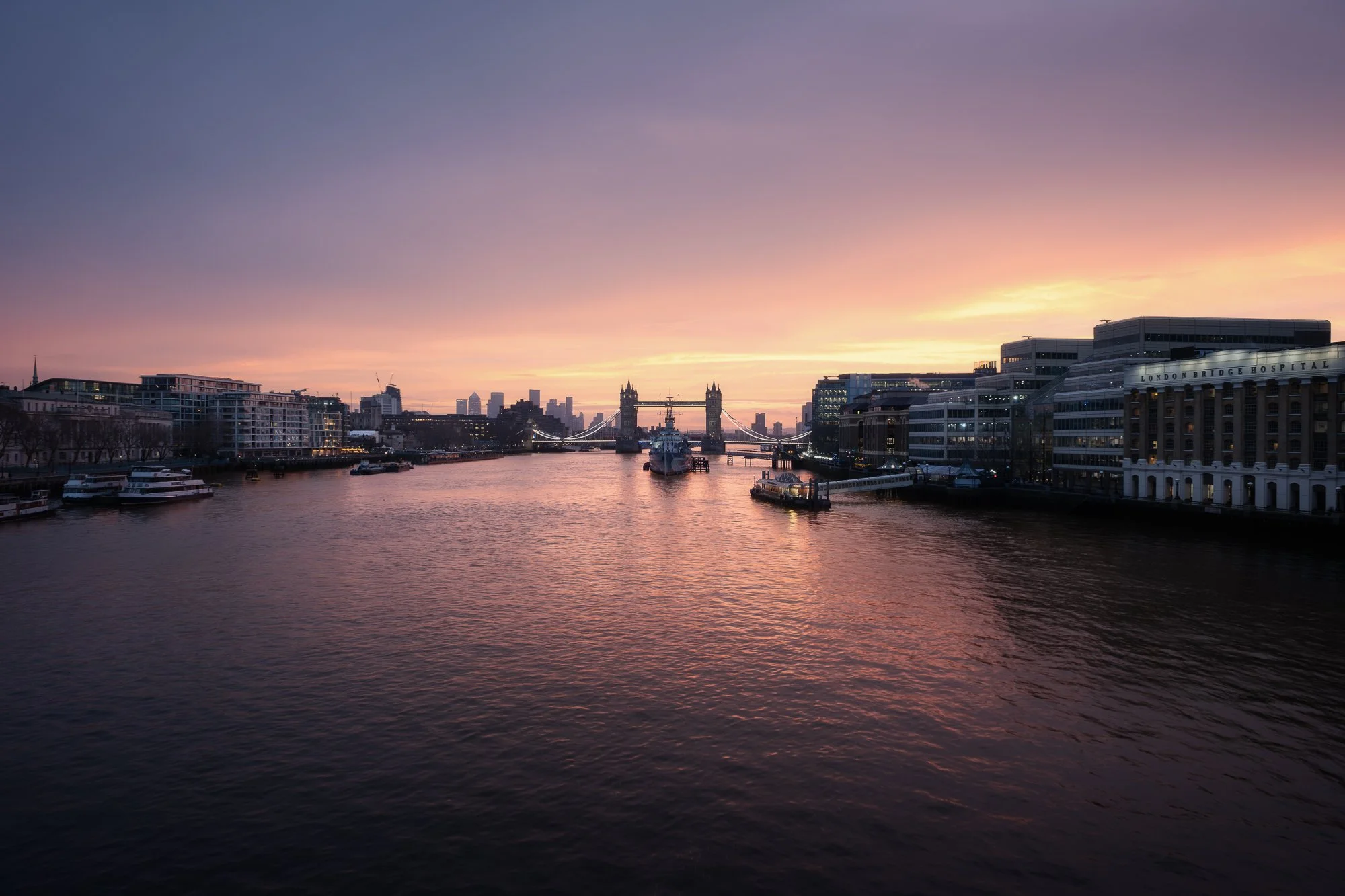 London cityscape at sunrise from London Bridge, featuring HMS Belfast and Tower Bridge